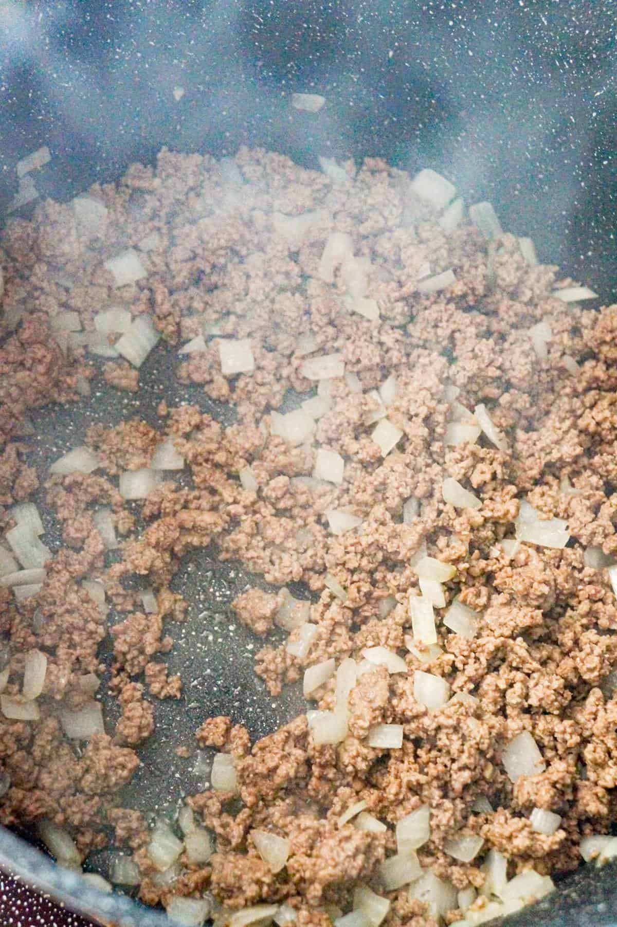 cooked ground beef and diced onions in a large pot
