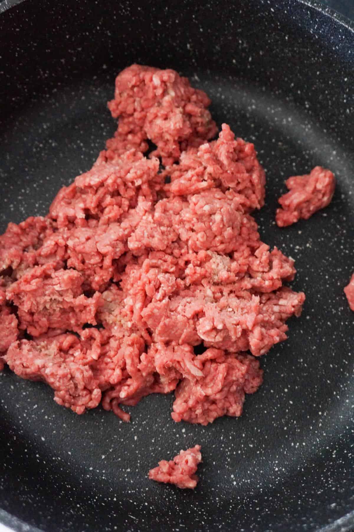 raw ground beef in a saute pan