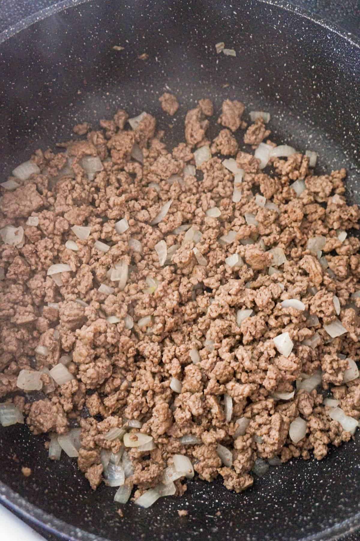 cooked ground beef and diced onions in a large saute pan