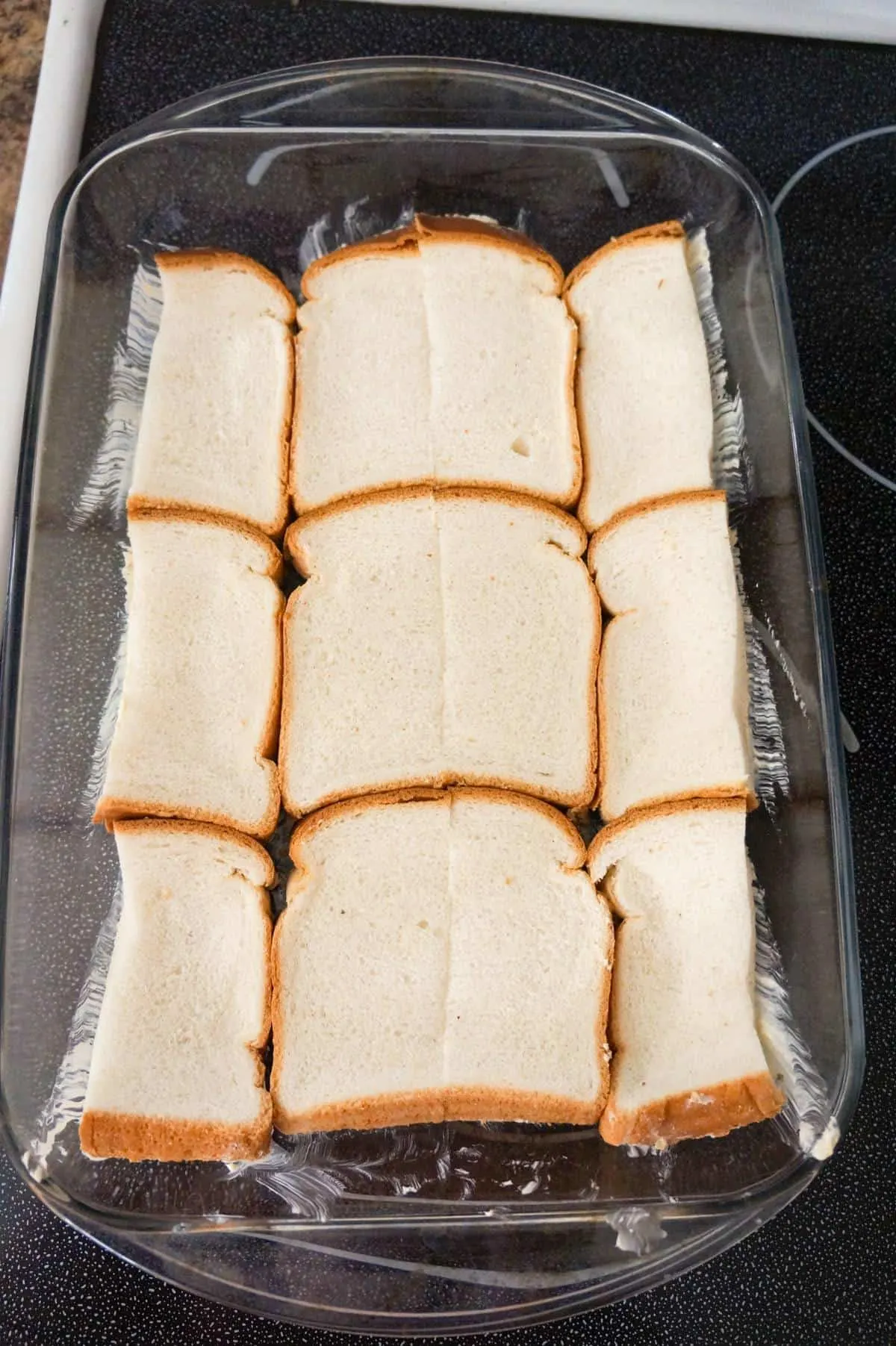 slices of bread in the bottom of a baking dish