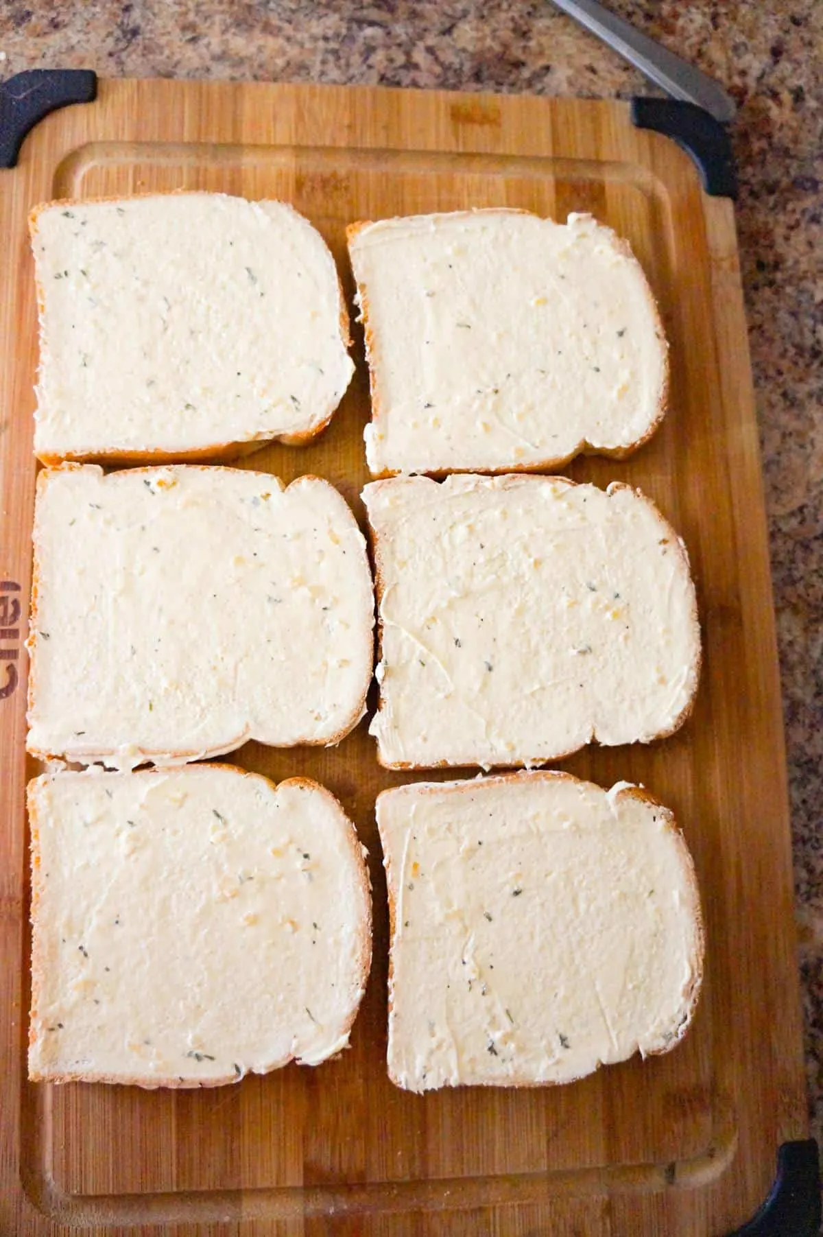 pieces of bread spread with garlic margarine on a cutting board