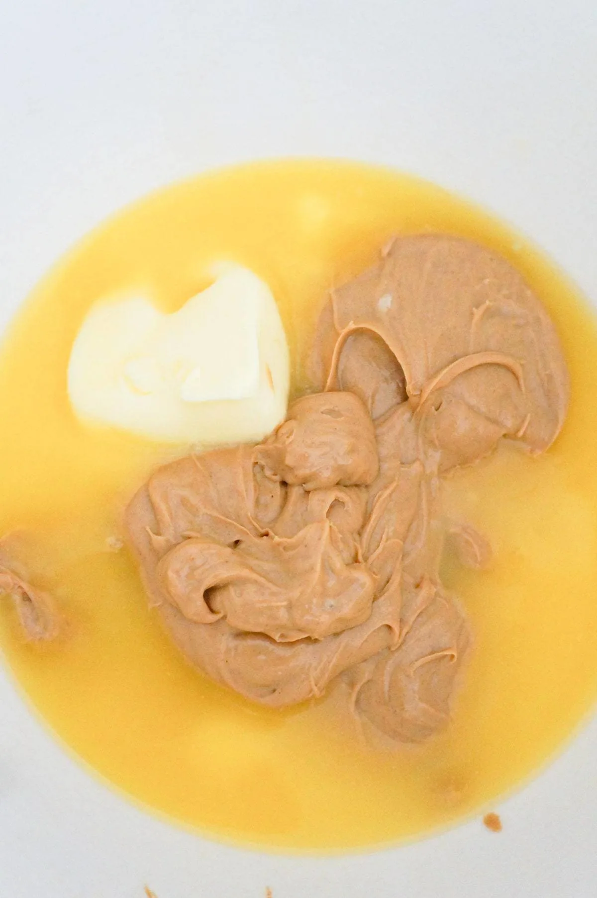 melted butter and peanut butter in a mixing bowl