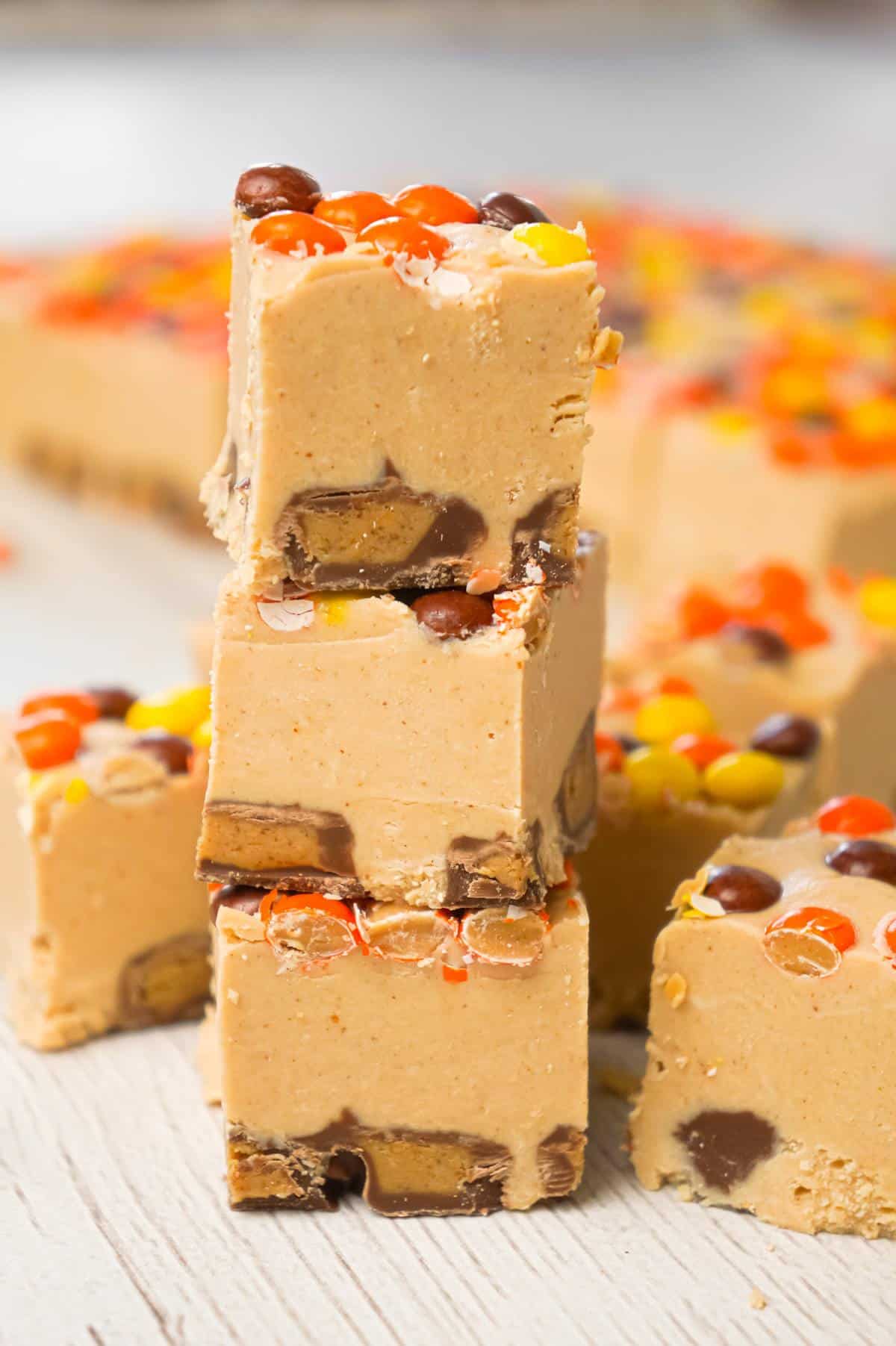 Peanut Butter Cup Fudge is an easy microwave fudge recipe made with vanilla frosting, peanut butter baking chips, smooth peanut butter and loaded with mini Reese's peanut butter cups and mini Reese's pieces.