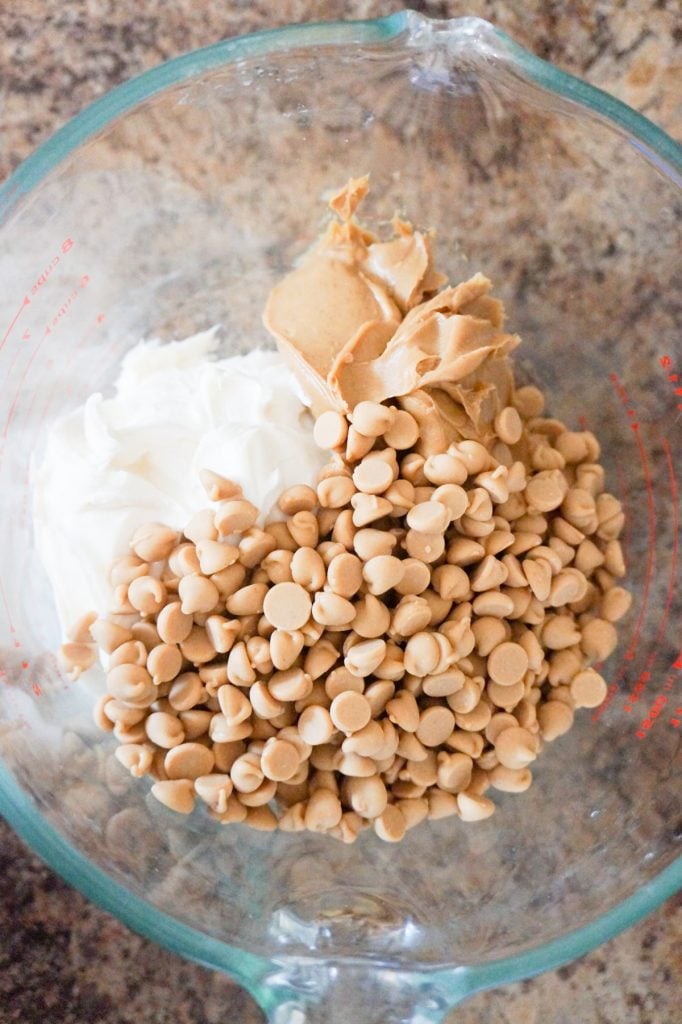 vanilla frosting, smooth peanut butter and peanut butter baking chips in a glass bowl