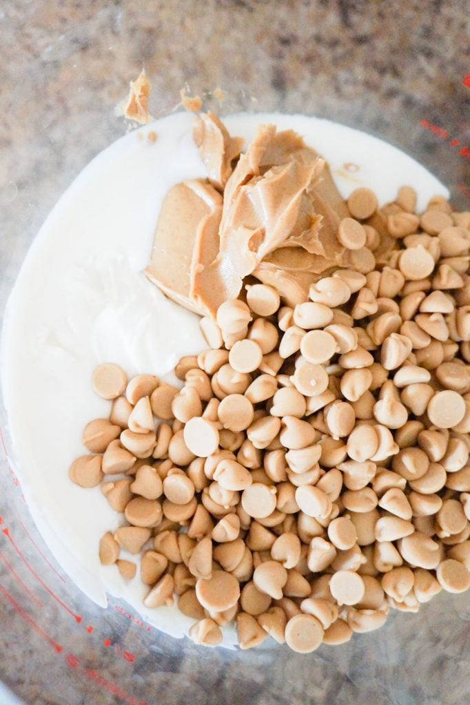 melted vanilla frosting, peanut butter and peanut butter baking chips in a glass bowl