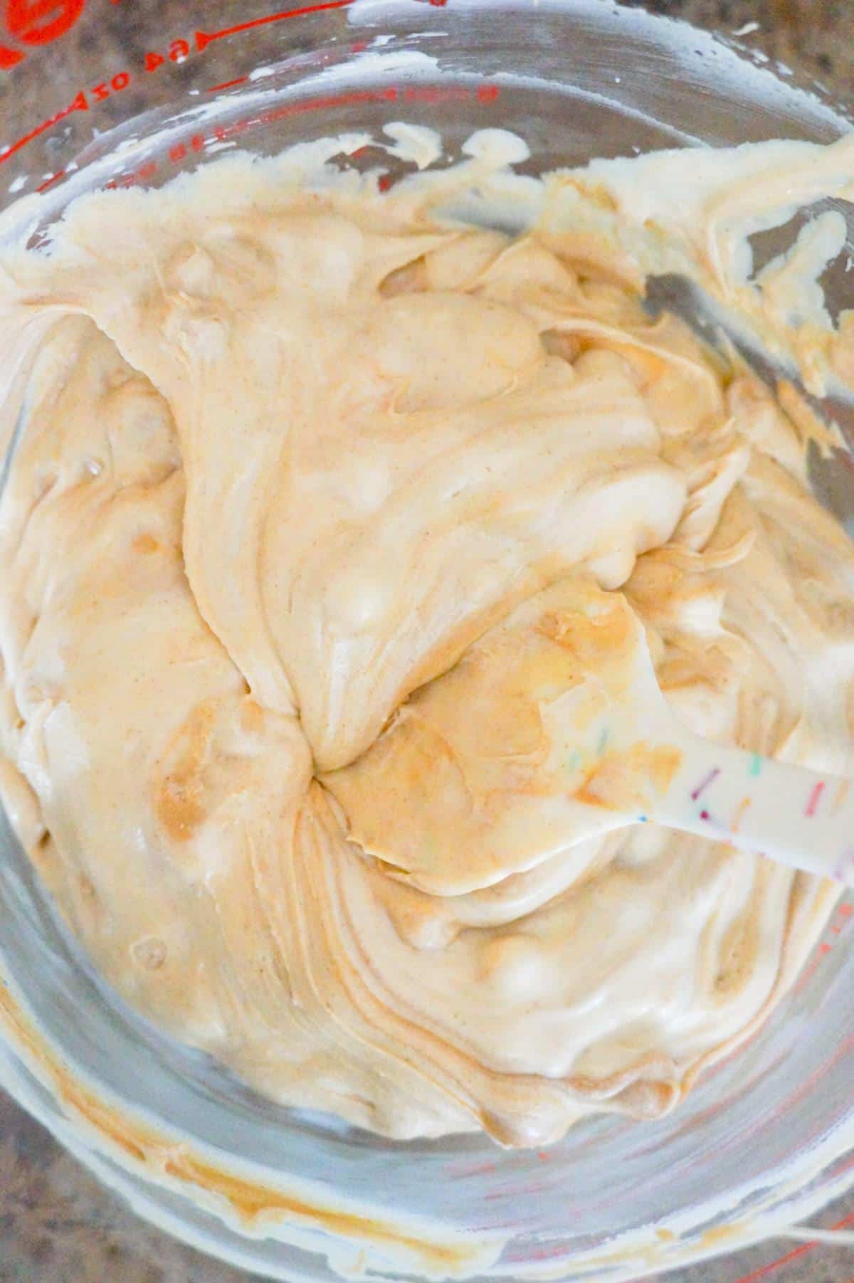 stirring peanut butter mixture in a glass bowl