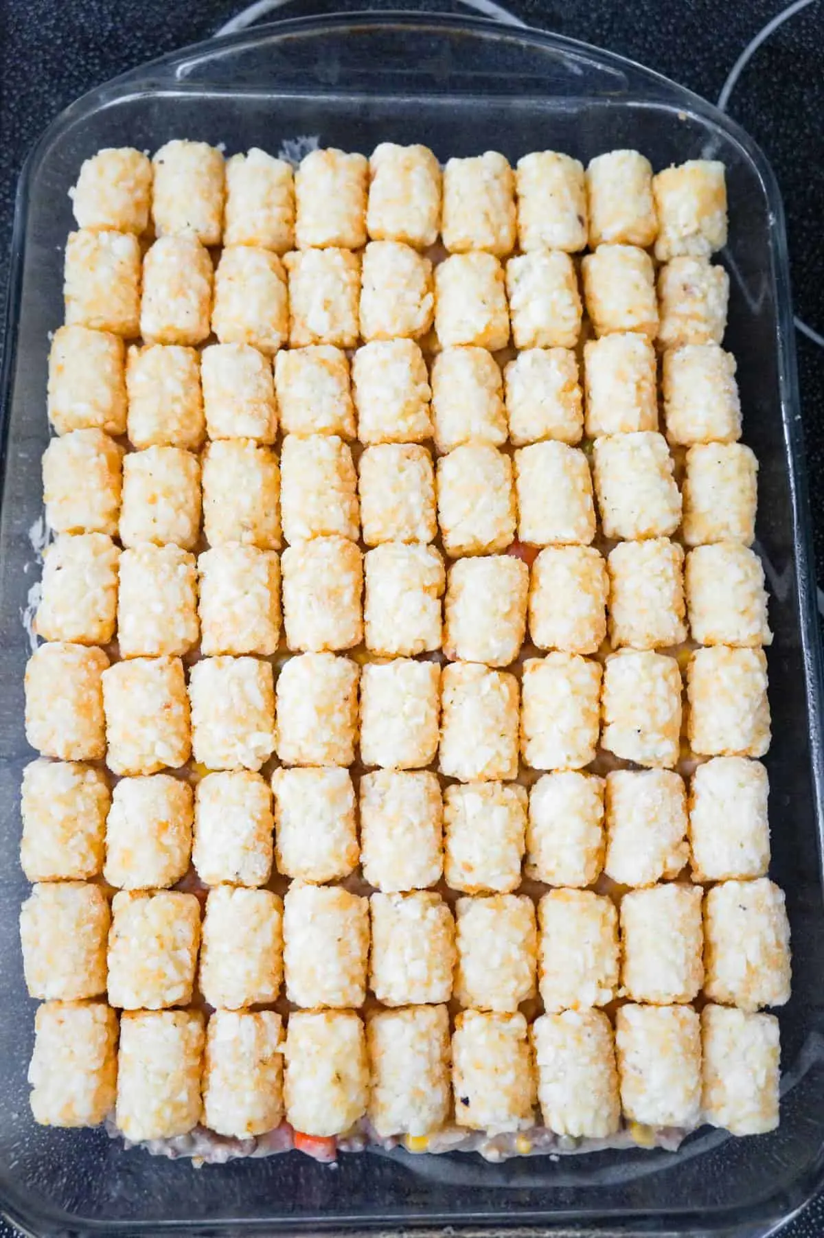 frozen tater tots on top of ground beef casserole before baking