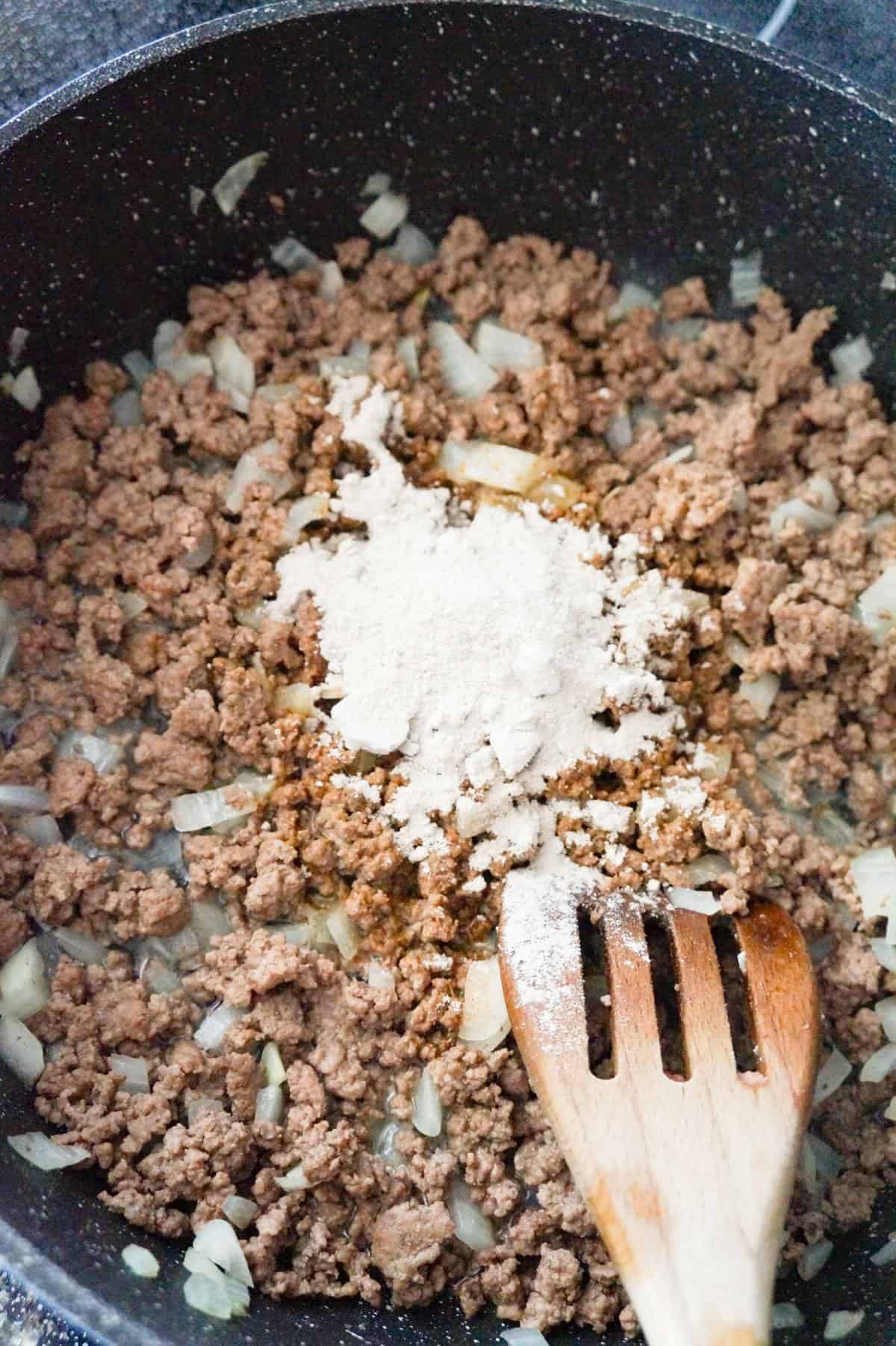 gravy mix on top of ground beef in a saute pan
