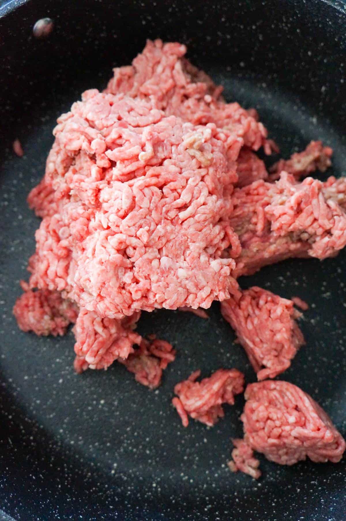 raw ground beef in a saute pan