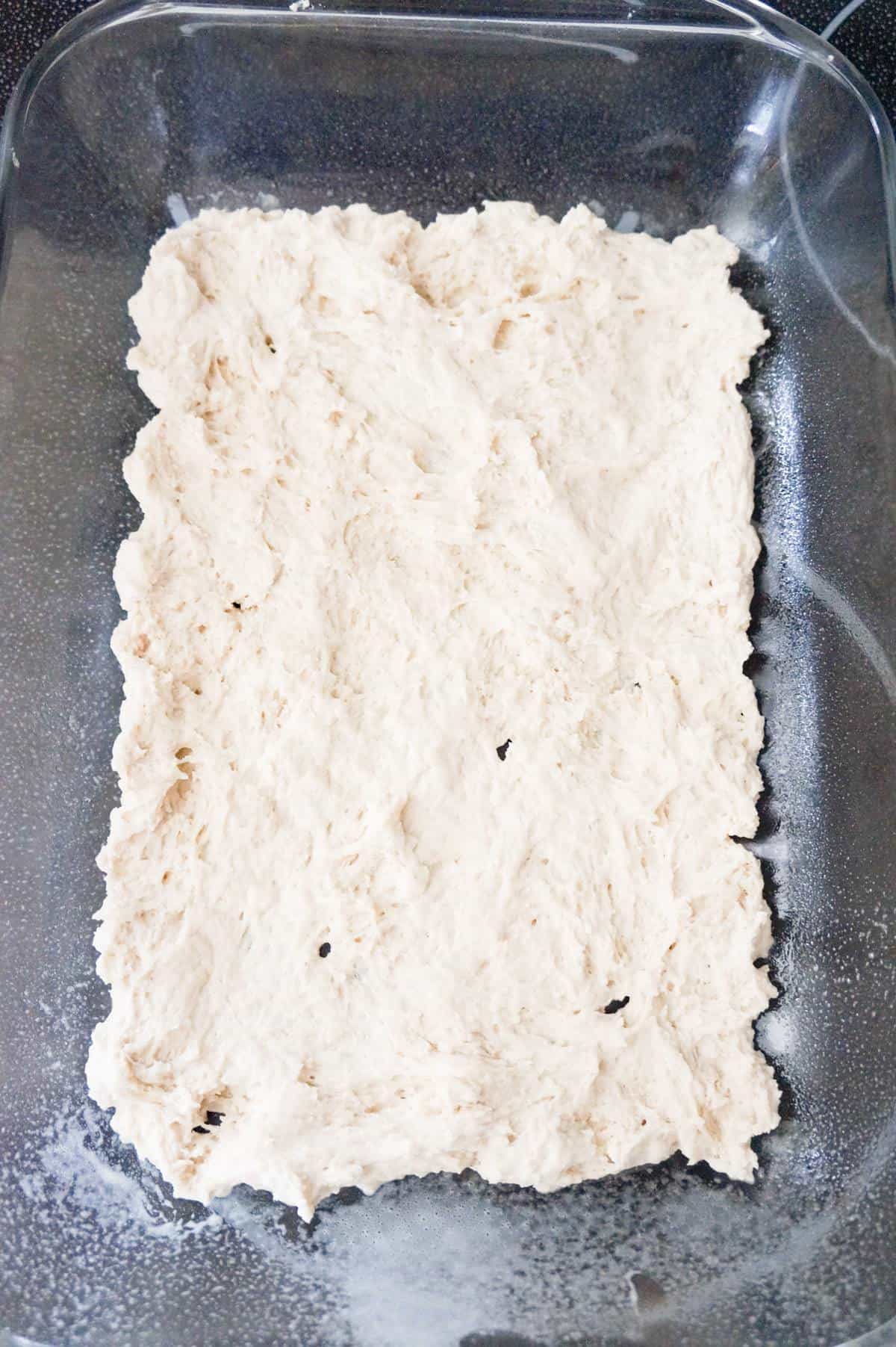 biscuit dough in the bottom of a glass baking dish