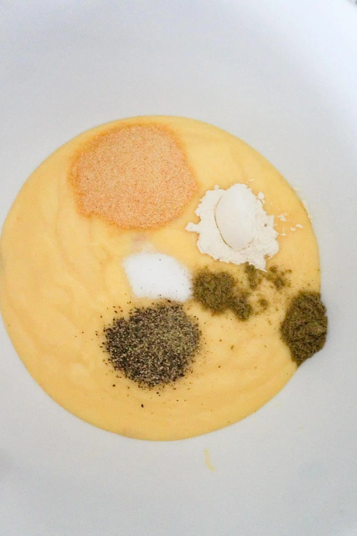 spices on top of condensed cream of chicken soup in a mixing bowl