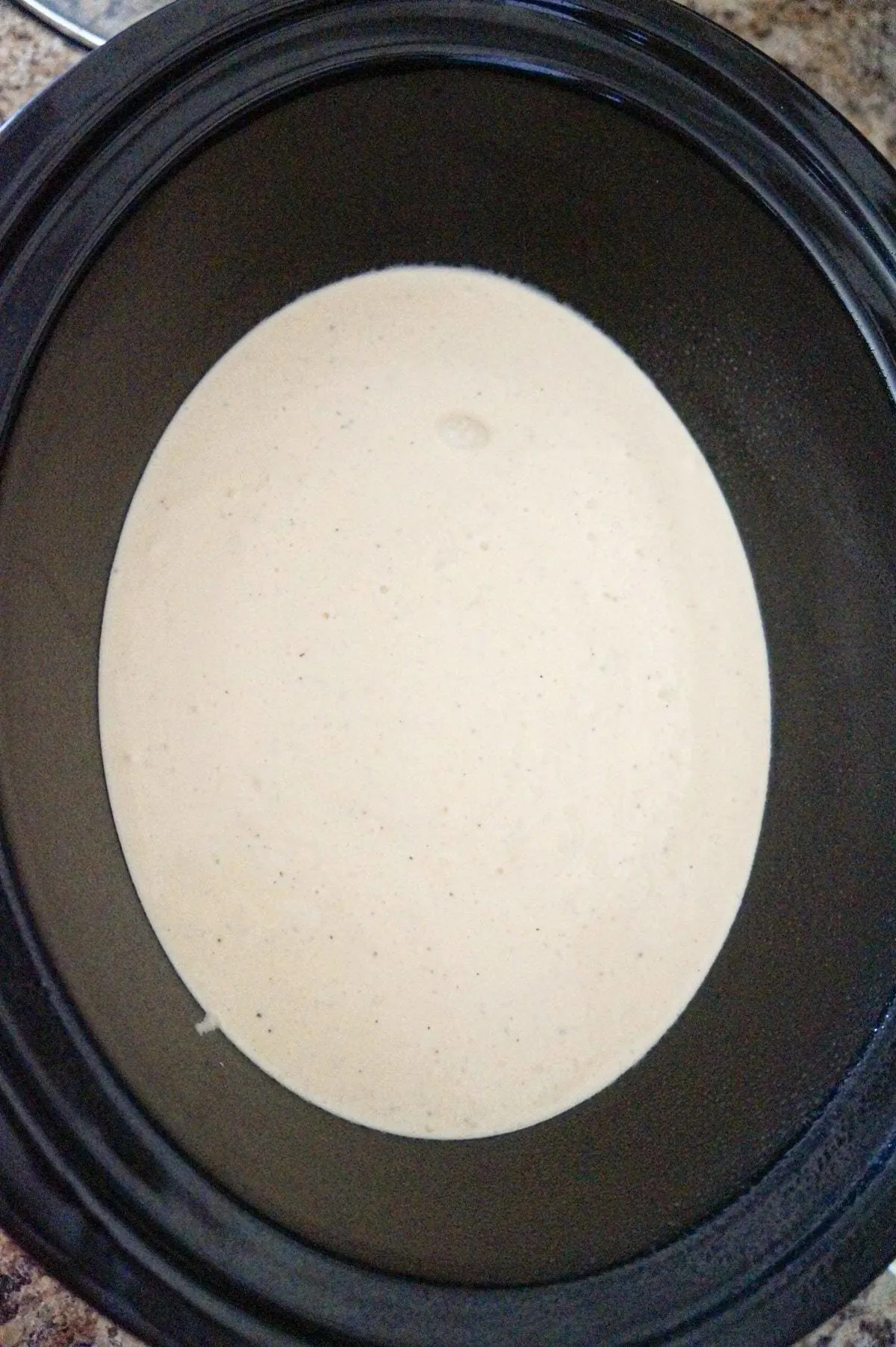 creamy cheddar soup mixture in a crock pot