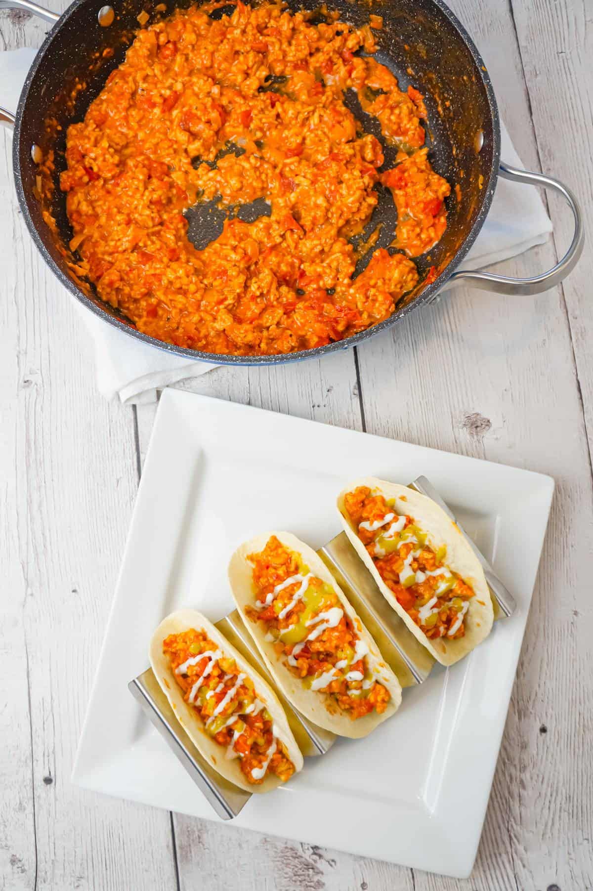 Ground Chicken Tacos are an easy weeknight dinner recipe made with lean ground chicken, chicken taco seasoning, Rotel diced tomatoes and green chilies and shredded cheese served in flour tortillas and drizzled with ranch and avocado dressing.