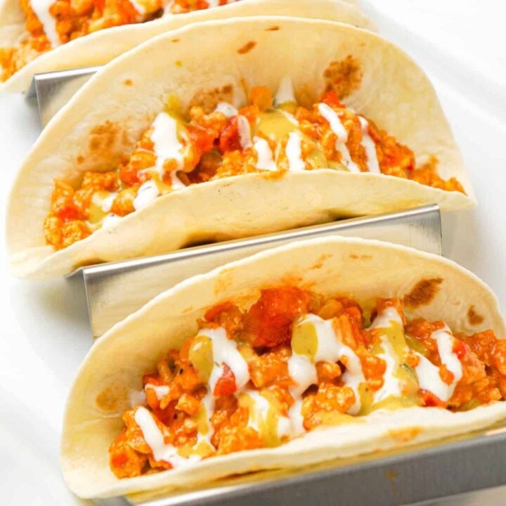 Ground Chicken Tacos are an easy weeknight dinner recipe made with lean ground chicken, chicken taco seasoning, Rotel diced tomatoes and green chilies and shredded cheese served in flour tortillas and drizzled with ranch and avocado dressing.