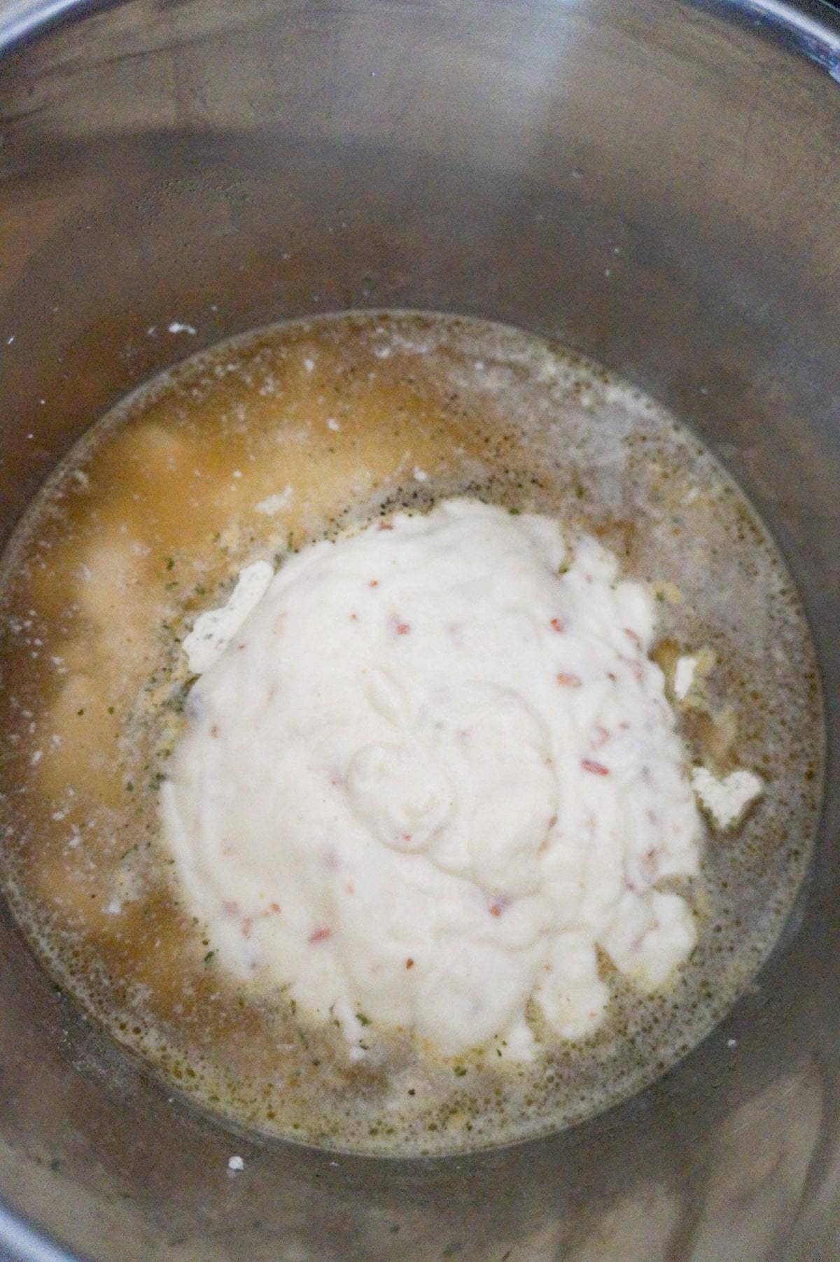 condensed cream of bacon soup on top of chicken and rice in broth in an Instant Pot
