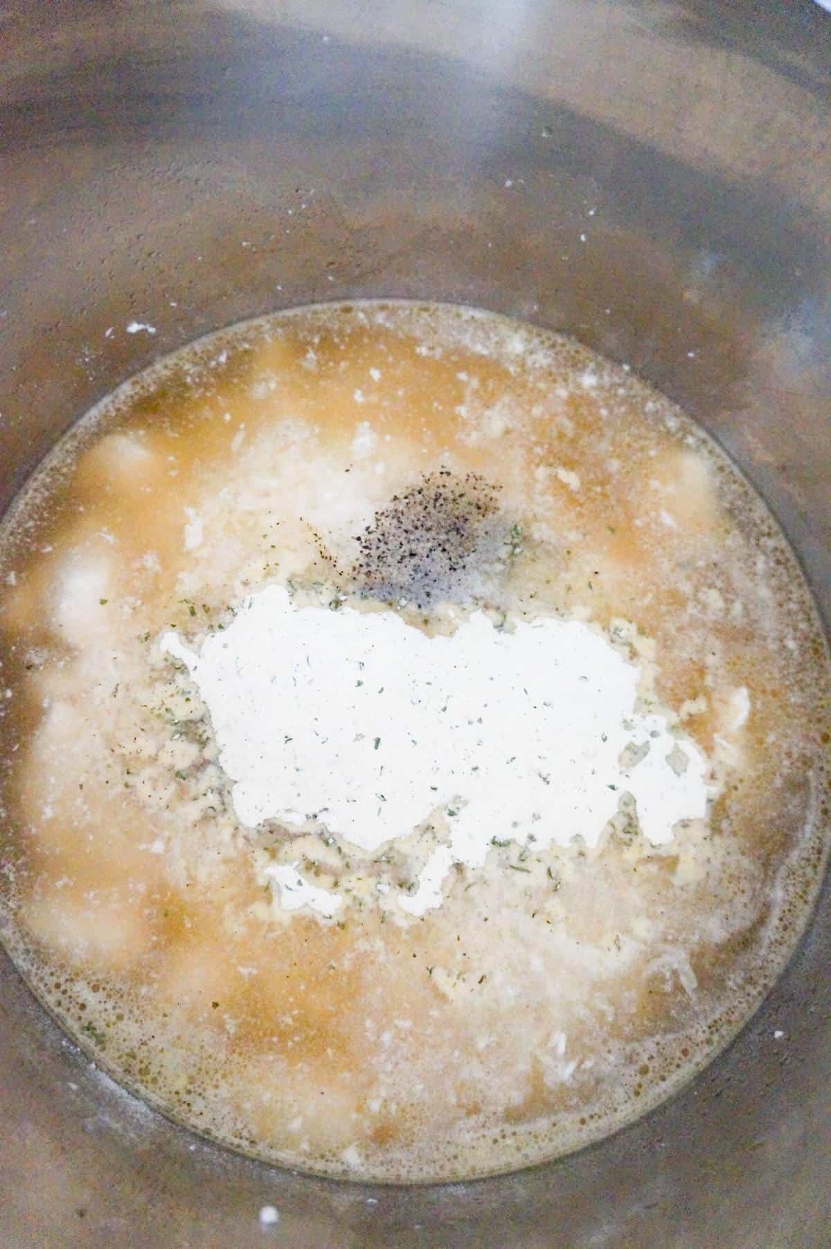 ranch dressing mix and pepper on top of chicken and rice in broth in an Instant Pot