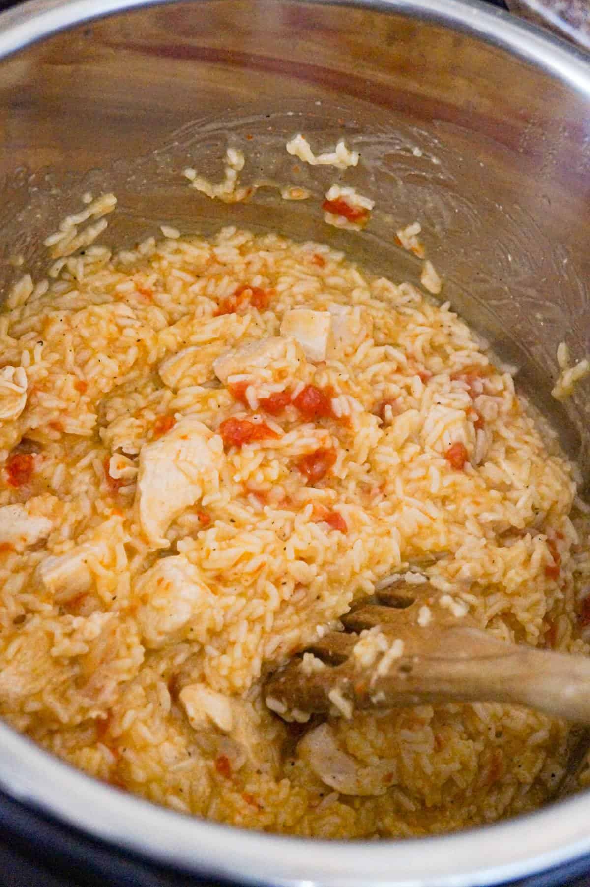 stirring chicken and rice in an Instant Pot