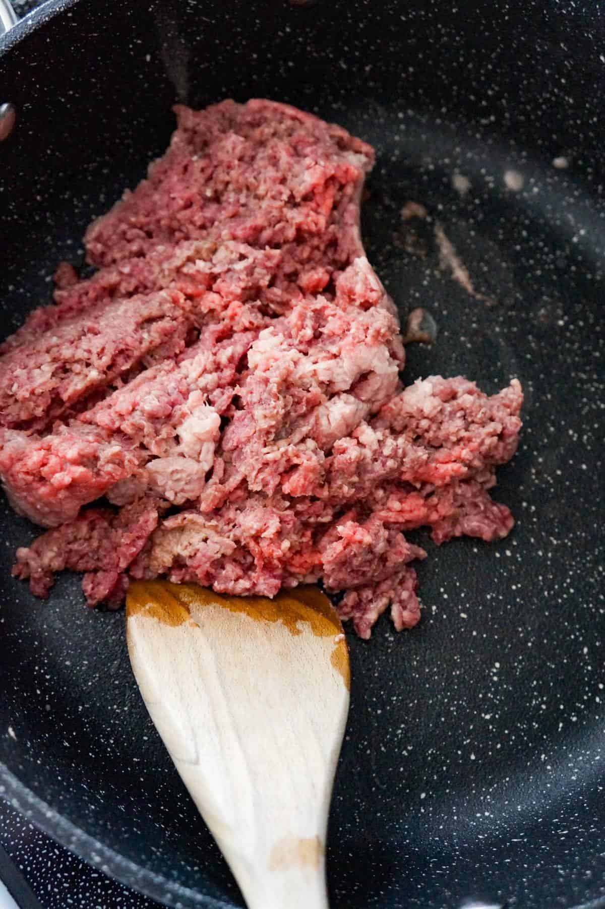 raw ground beef in a saute pan