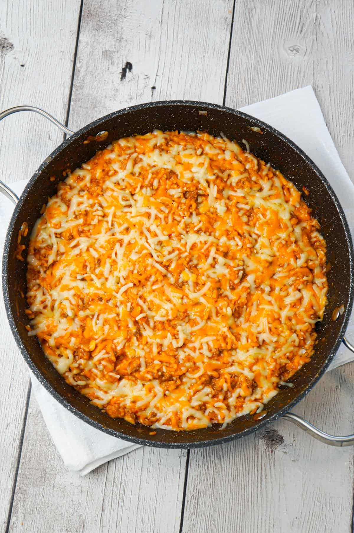 One Pot Sloppy Joe Ground Beef and Rice is an easy stove top dinner recipe made with ground beef and minute rice all tossed in sloppy joe sauce and loaded with shredded mozzarella and cheddar cheese.