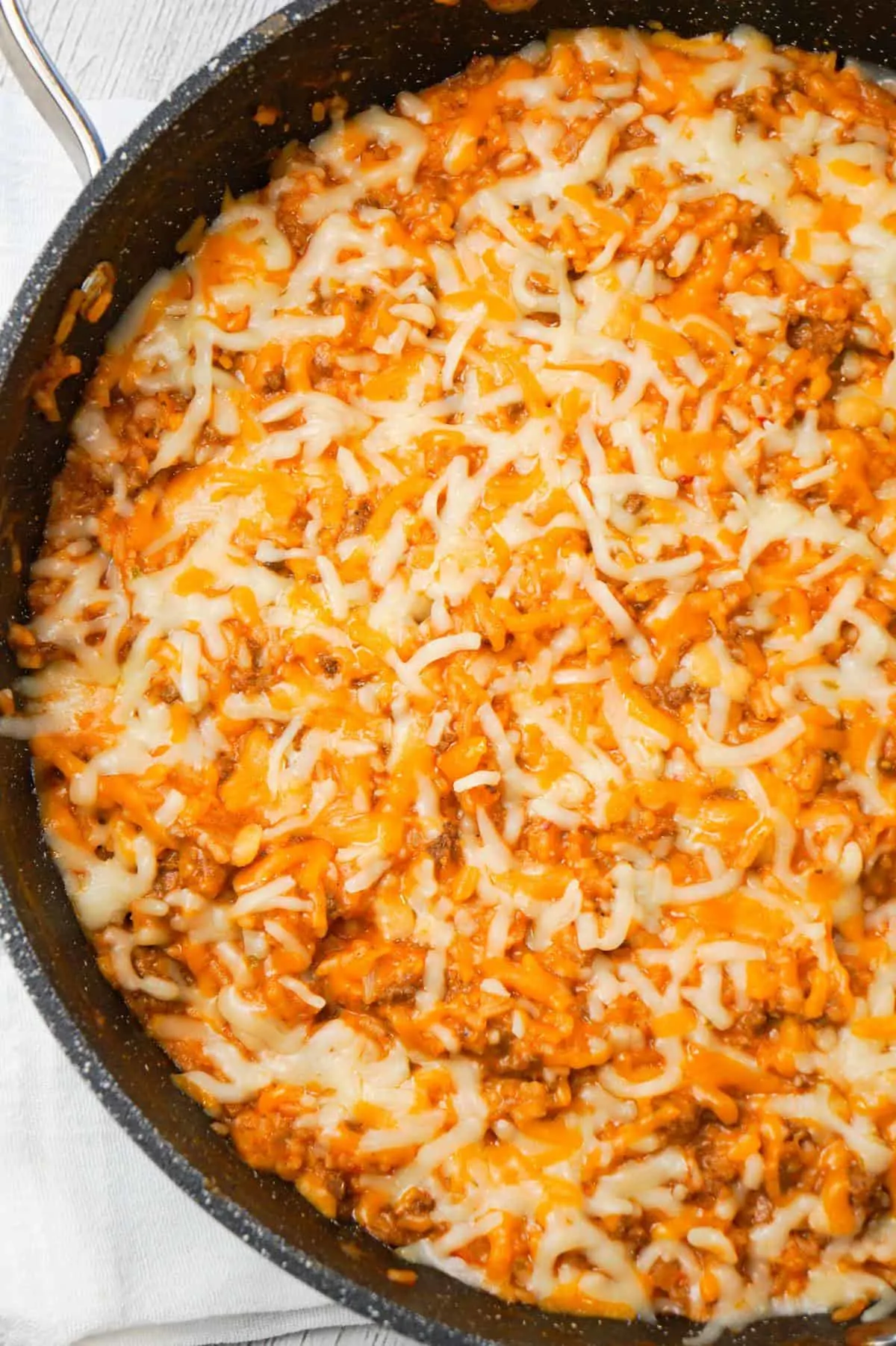 One Pot Sloppy Joe Ground Beef and Rice is an easy stove top dinner recipe made with ground beef and minute rice all tossed in sloppy joe sauce and loaded with shredded mozzarella and cheddar cheese.