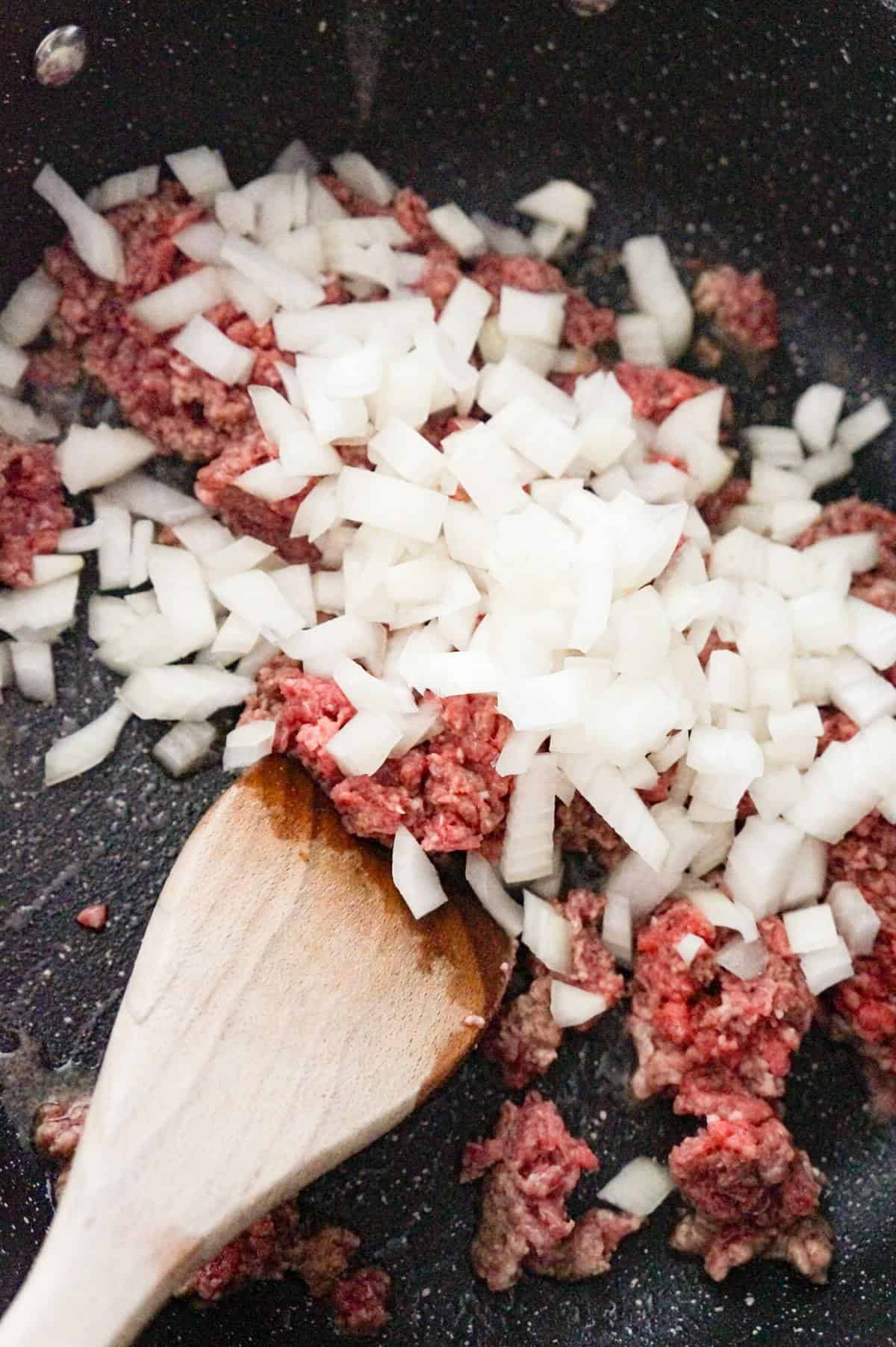 diced onions and raw ground beef in a saute pan