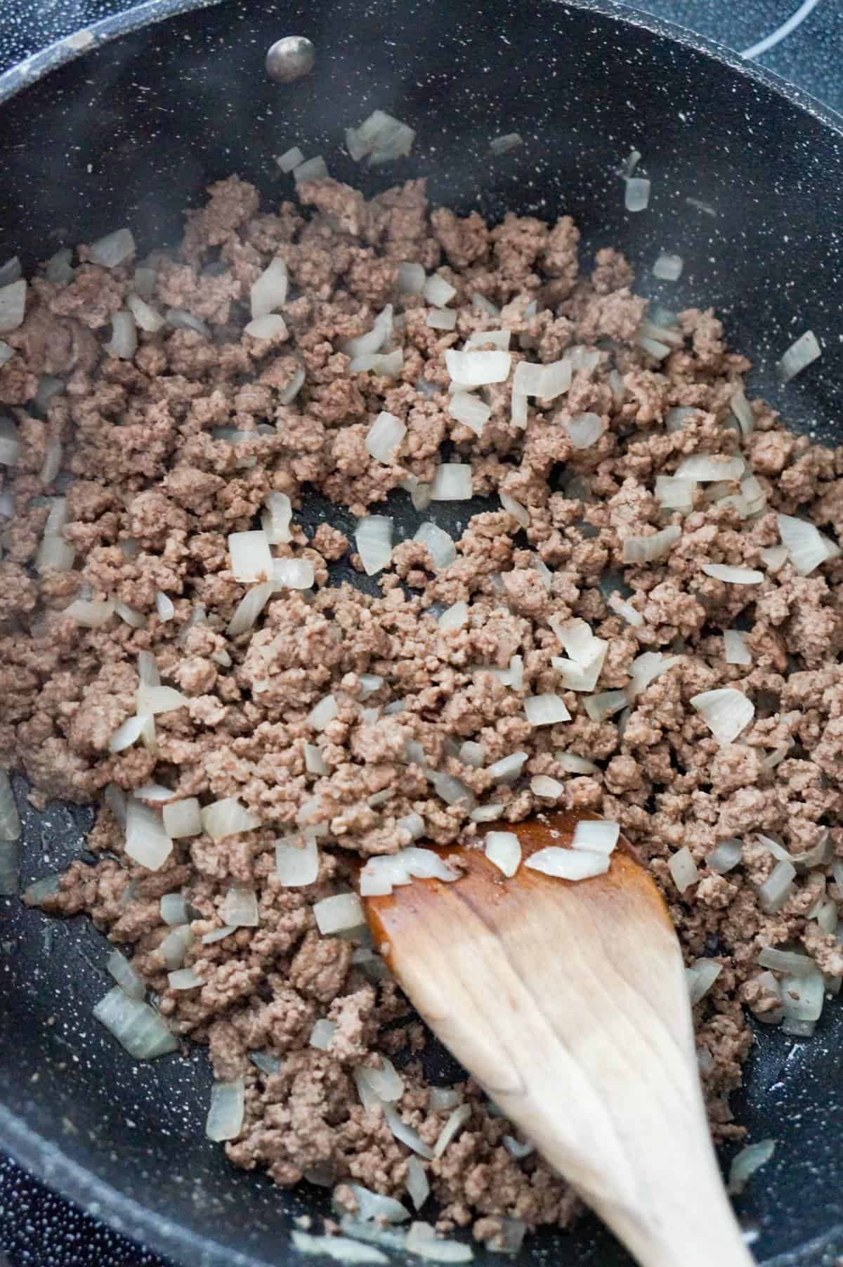 cooked ground beef and diced onions in a saute pan