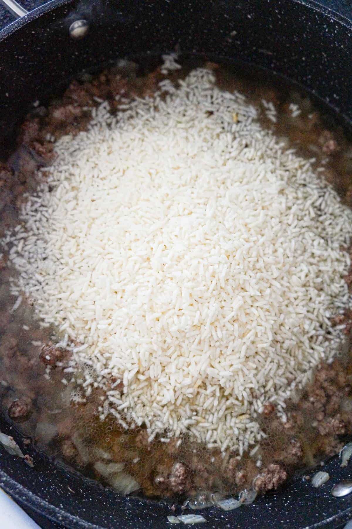 minute rice on top of ground beef in a saute pan