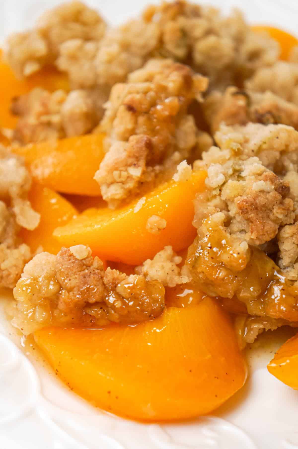 Peach Crumble is a delicious dessert recipe made with canned peaches and topped with a crunchy crumble topping with hints of cinnamon and citrus.