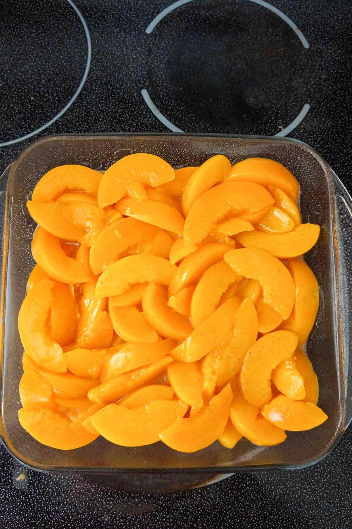 peach slices in a square baking dish