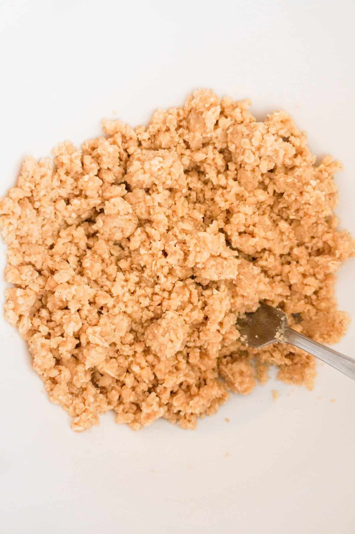 crumble topping mixture being stirred in a mixing bowl