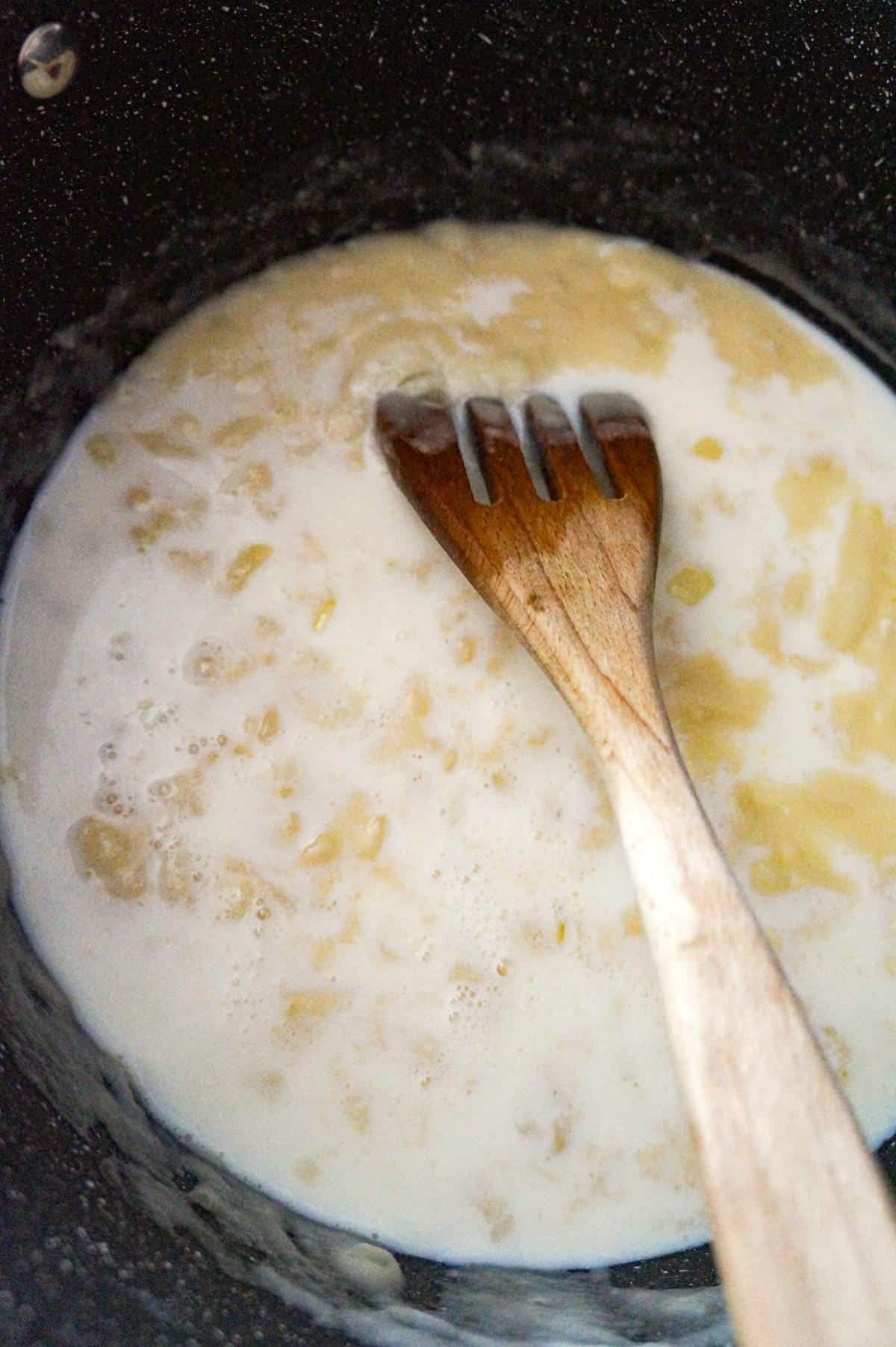 milk added to broth and flour mixture in a large pot