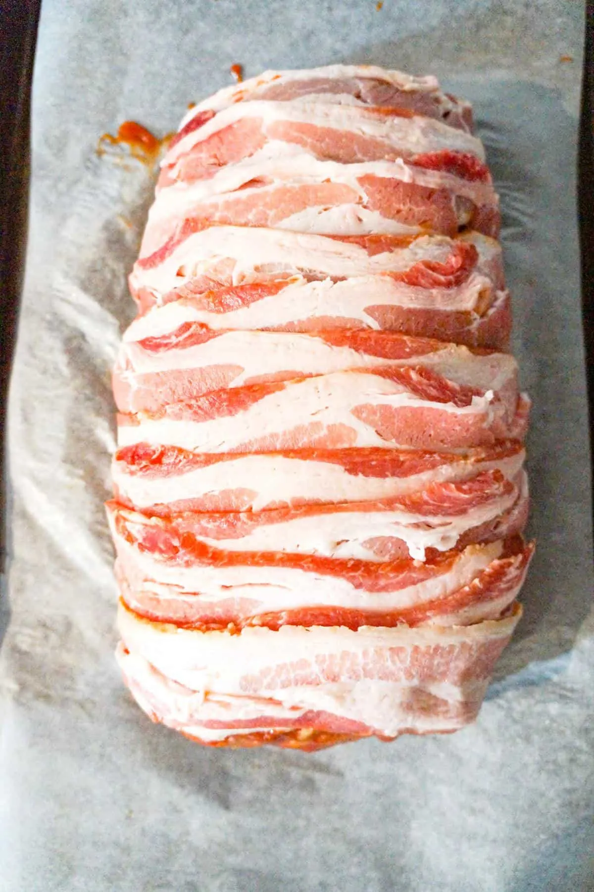 raw strips of bacon wrapped around meatloaf