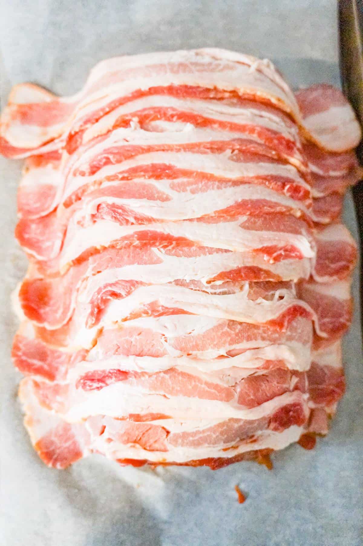 raw strips of bacon draped over meatloaf