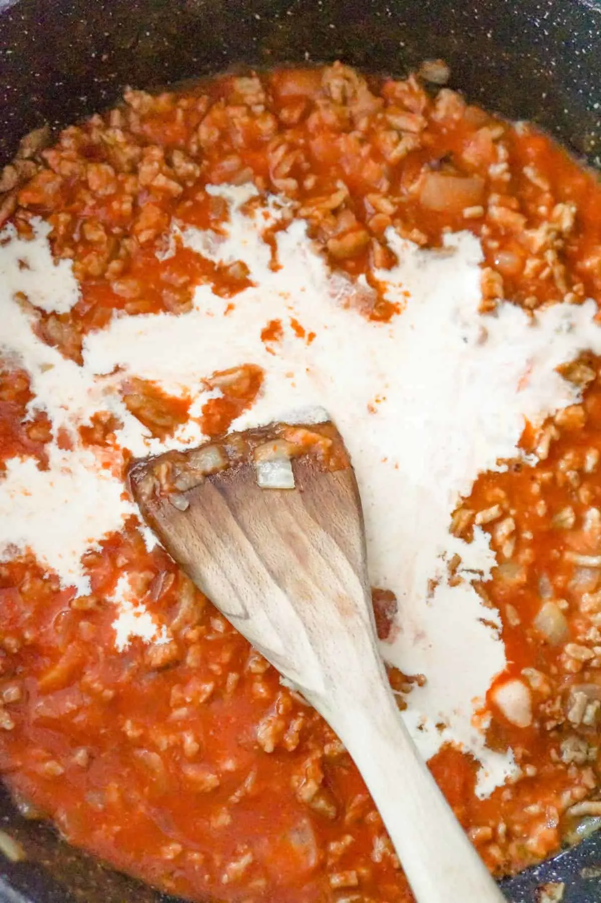 heavy cream added to ground chicken and tomato sauce mixture in a saute pan