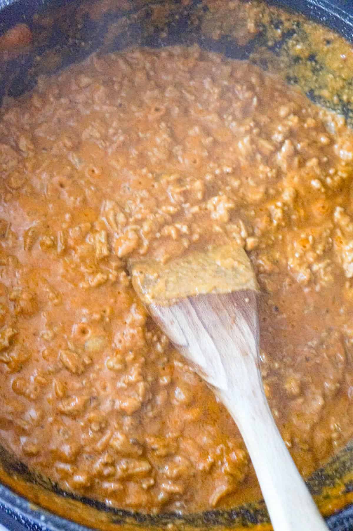 butter chicken sloppy joe mixture being stirred in a pan