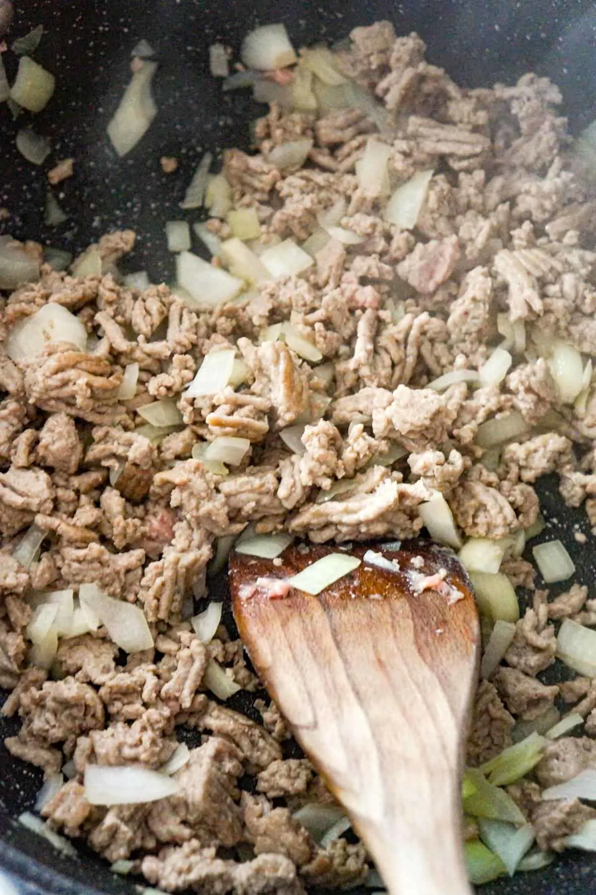 diced onions and ground chicken cooking in a saute pan