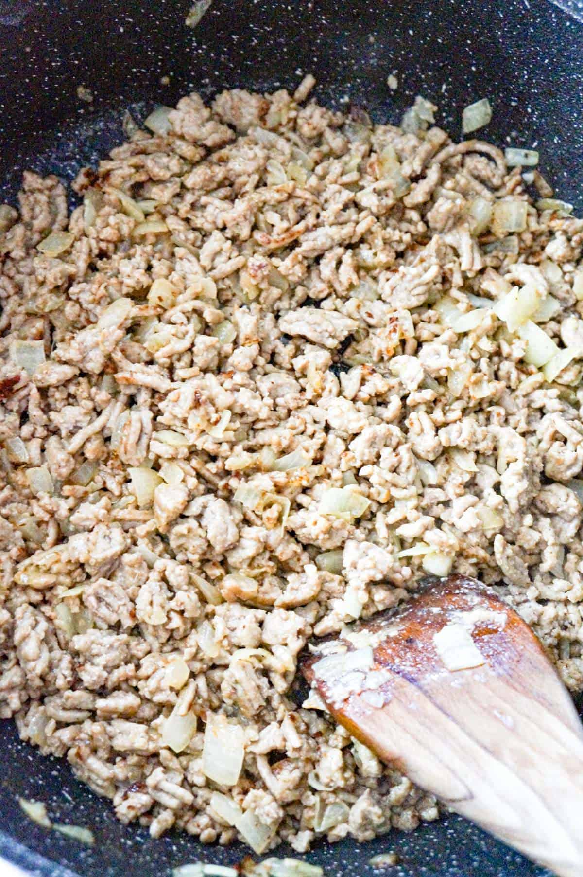 cooked ground chicken and diced onions in a saute pan