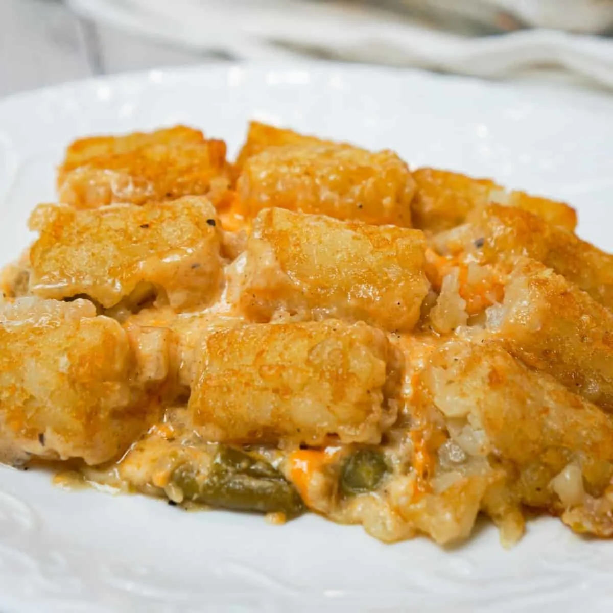 Green Bean Casserole with Tater Tots is an easy side dish recipe made with canned green beans and loaded with cream of mushroom soup, French's fried onions, shredded cheese and tater tots.