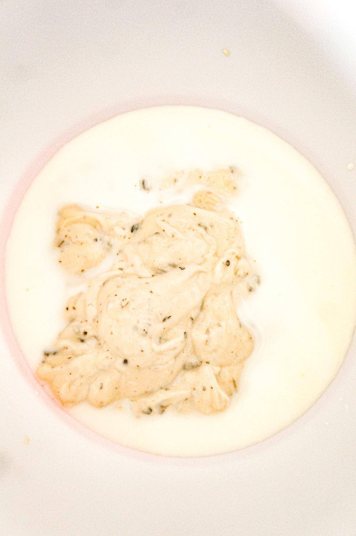 condensed cream of mushroom soup and milk in a mixing bowl