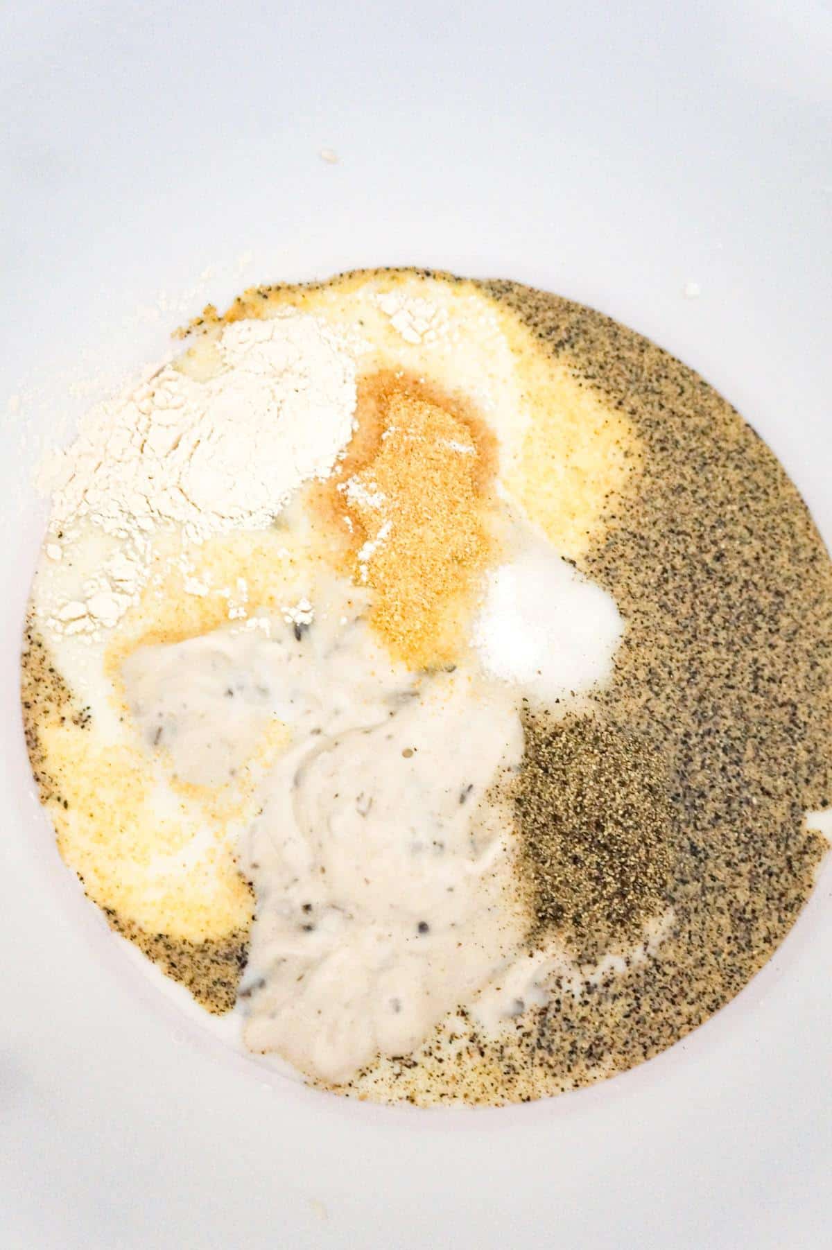 condensed cream of mushroom soup, milk and spices in a mixing bowl