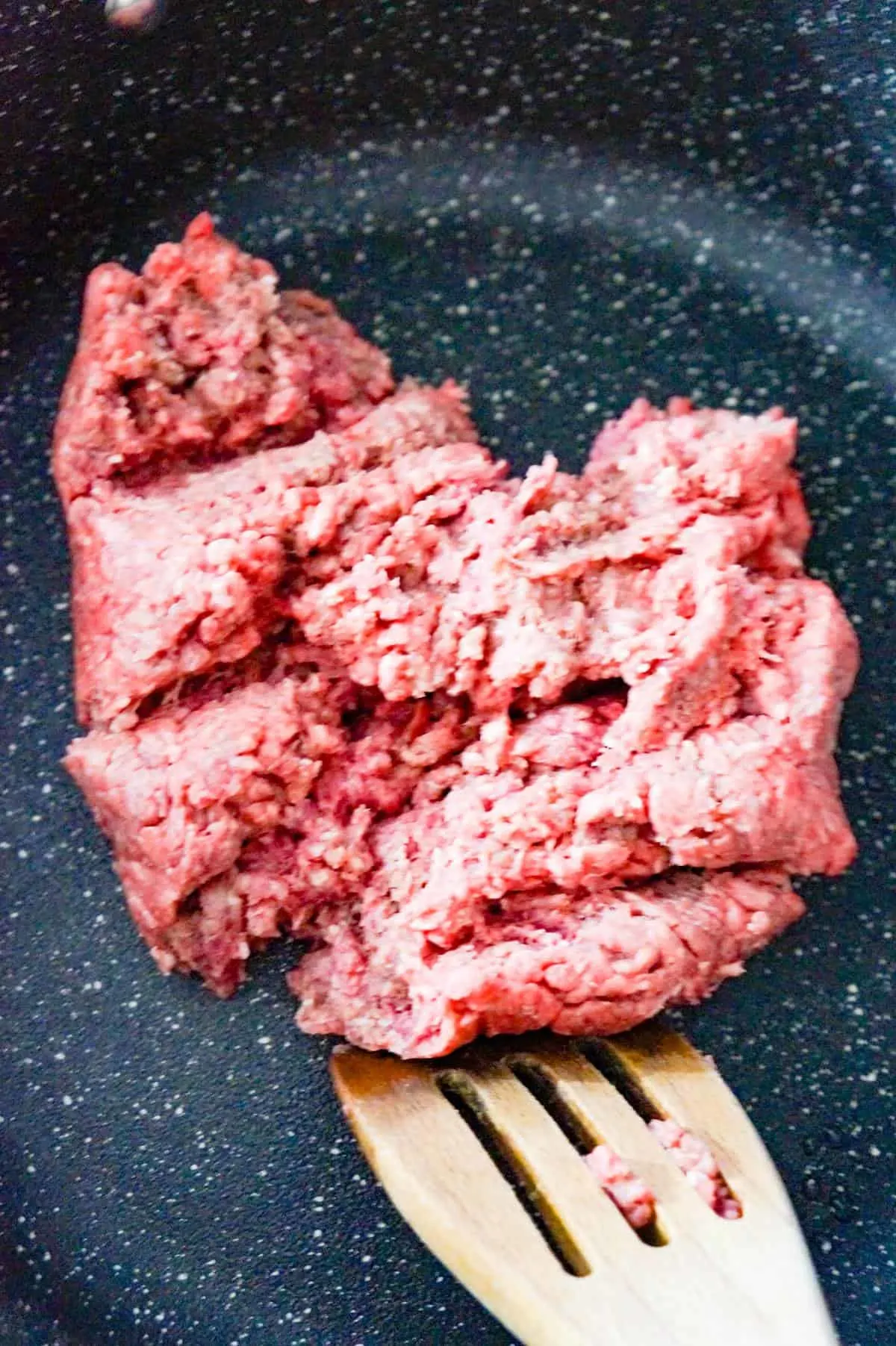 raw ground beef in a large saute pan