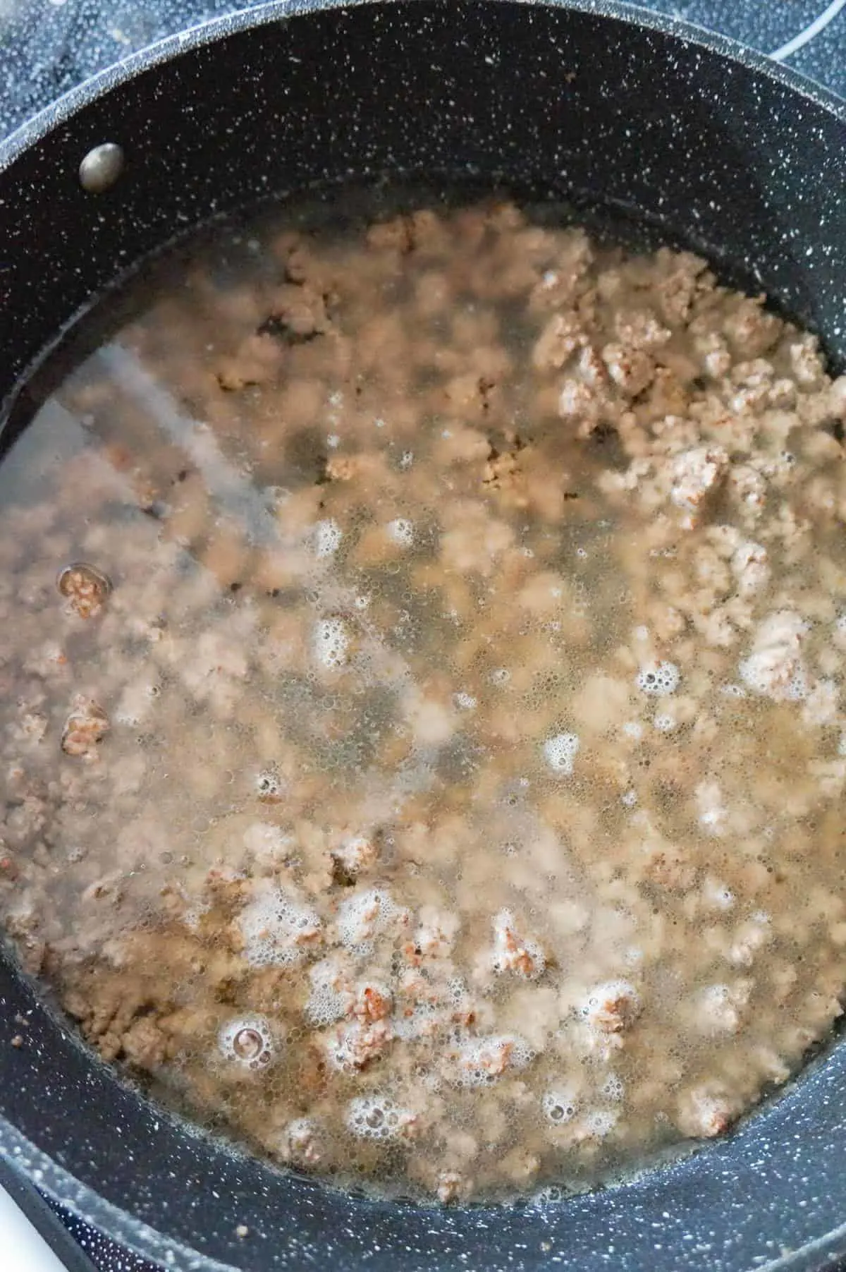water and cooked ground beef in a pan
