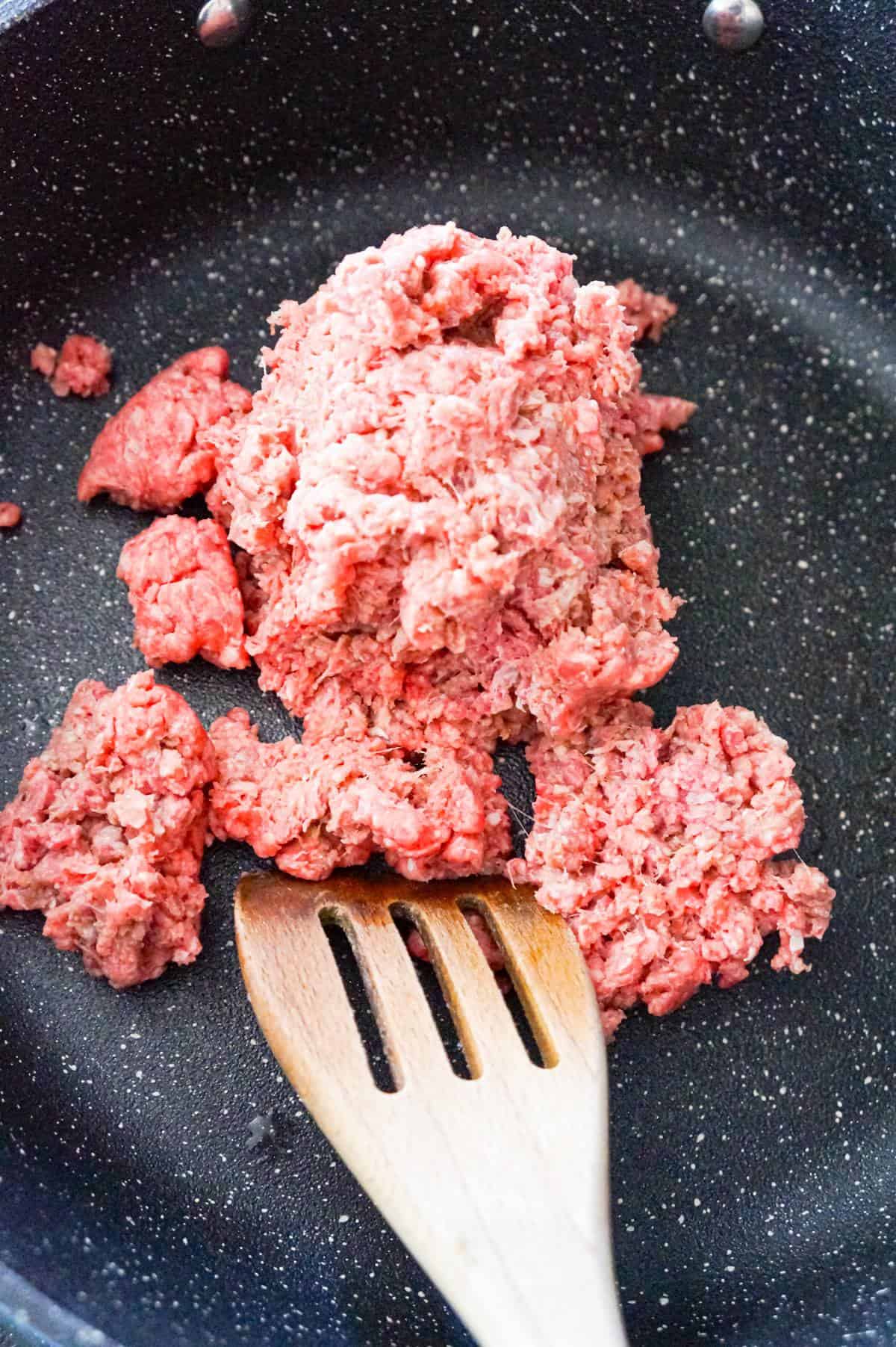 raw ground beef in a saute pan