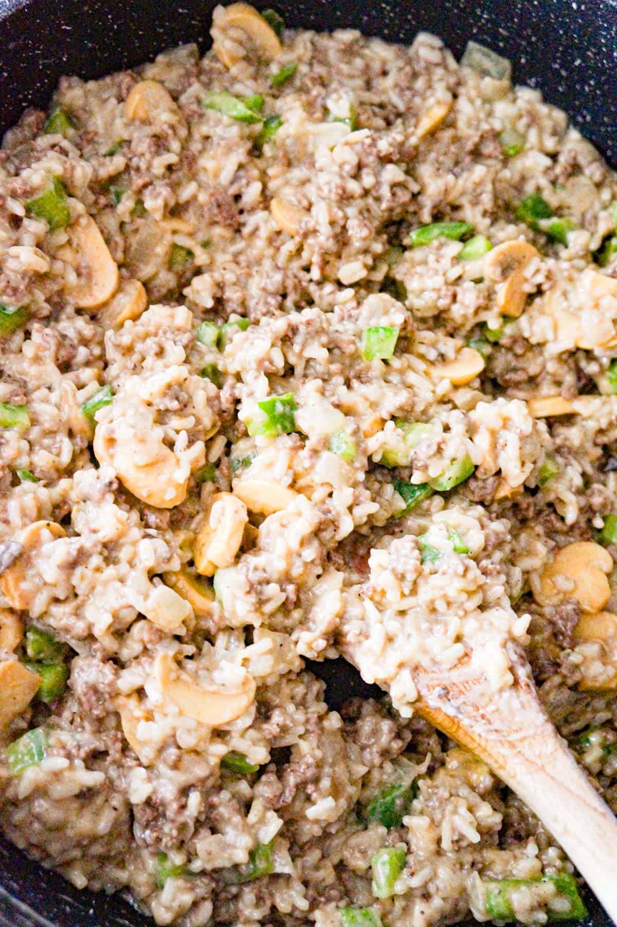 mushroom and diced green peppers on top of ground beef and rice