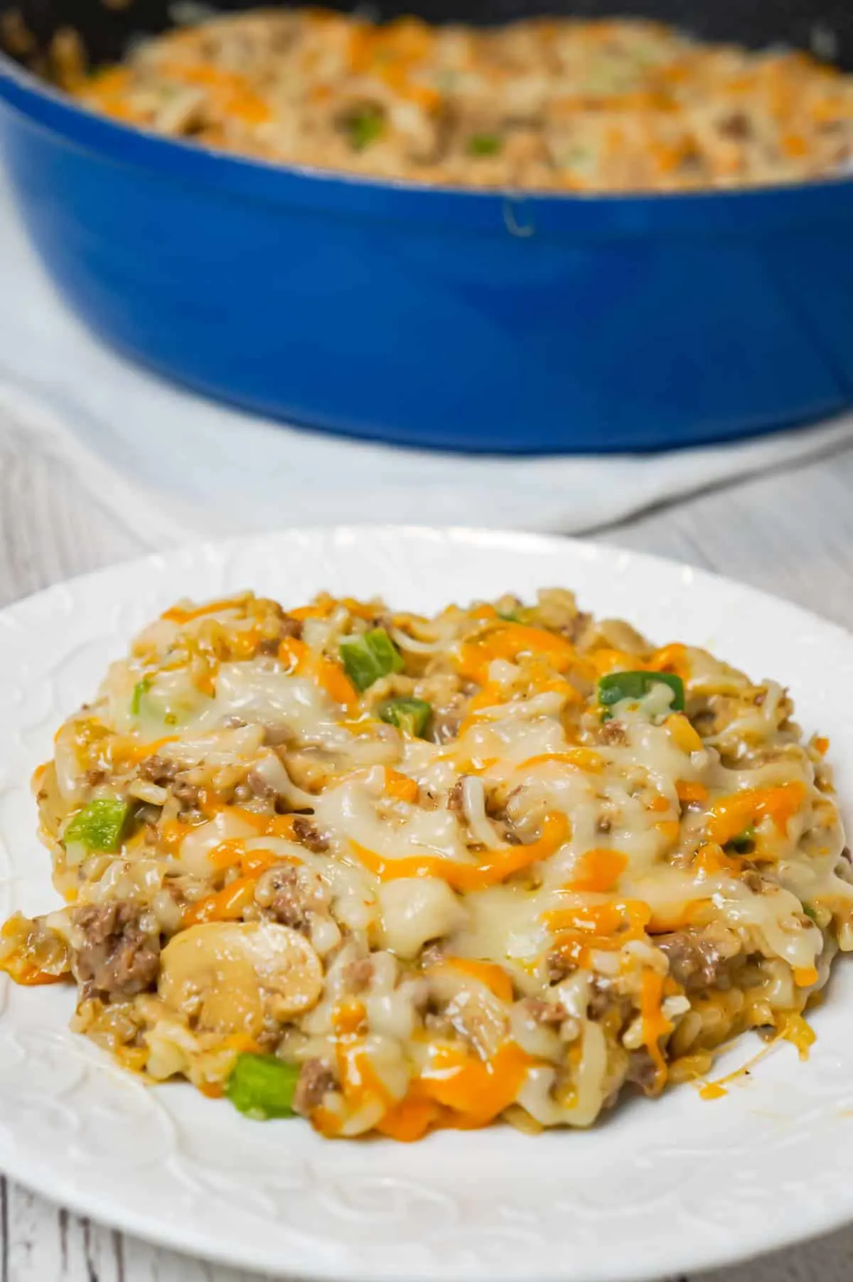 One Pot Philly Cheese Steak Ground Beef and Rice is an easy stove top dinner recipe loaded with hamburger meat, green peppers, sliced mushrooms, instant rice, cream of mushroom soup and shredded cheese.