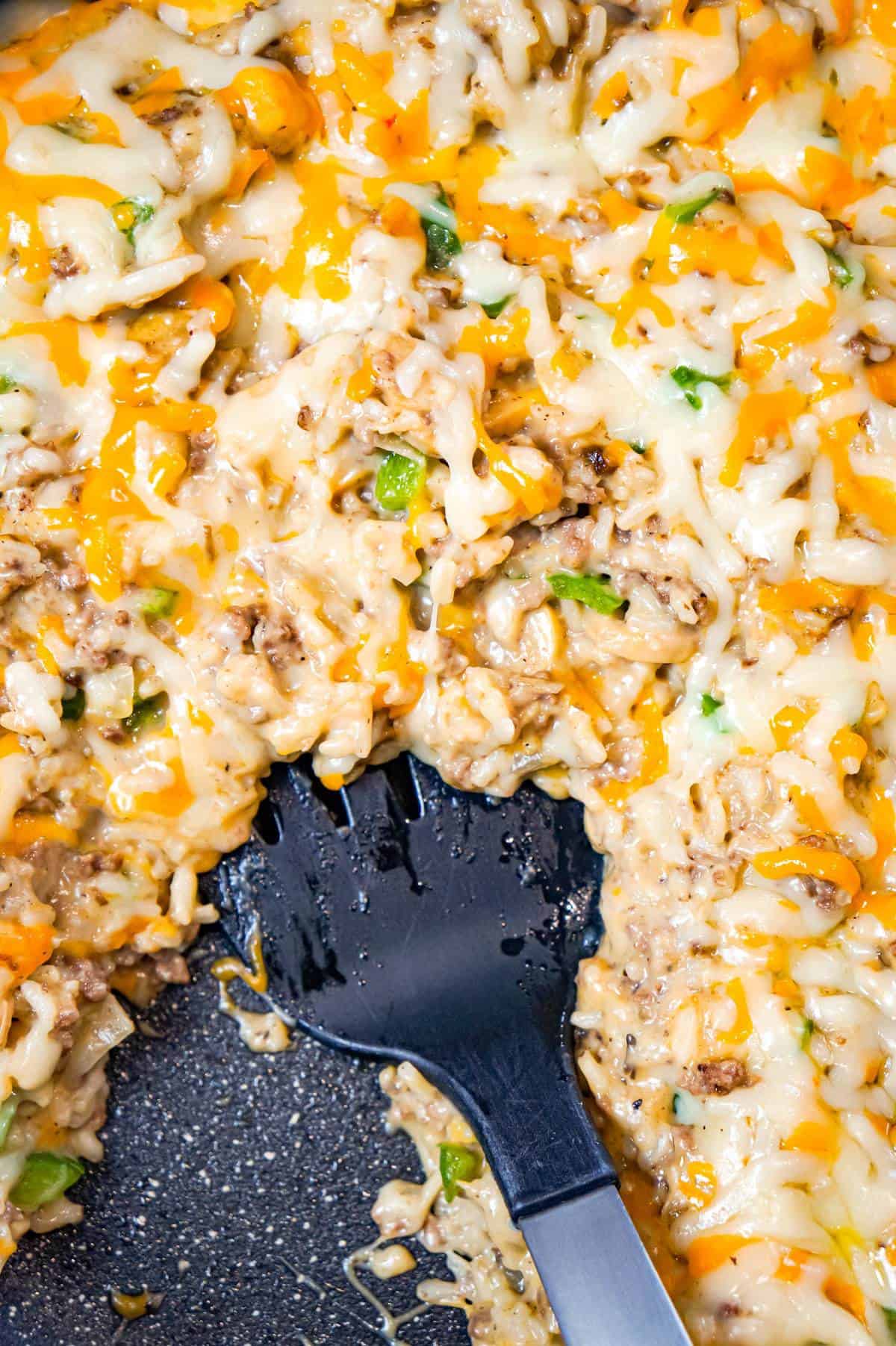 One Pot Philly Cheese Steak Ground Beef and Rice is an easy stove top dinner recipe loaded with hamburger meat, green peppers, sliced mushrooms, instant rice, cream of mushroom soup and shredded cheese.