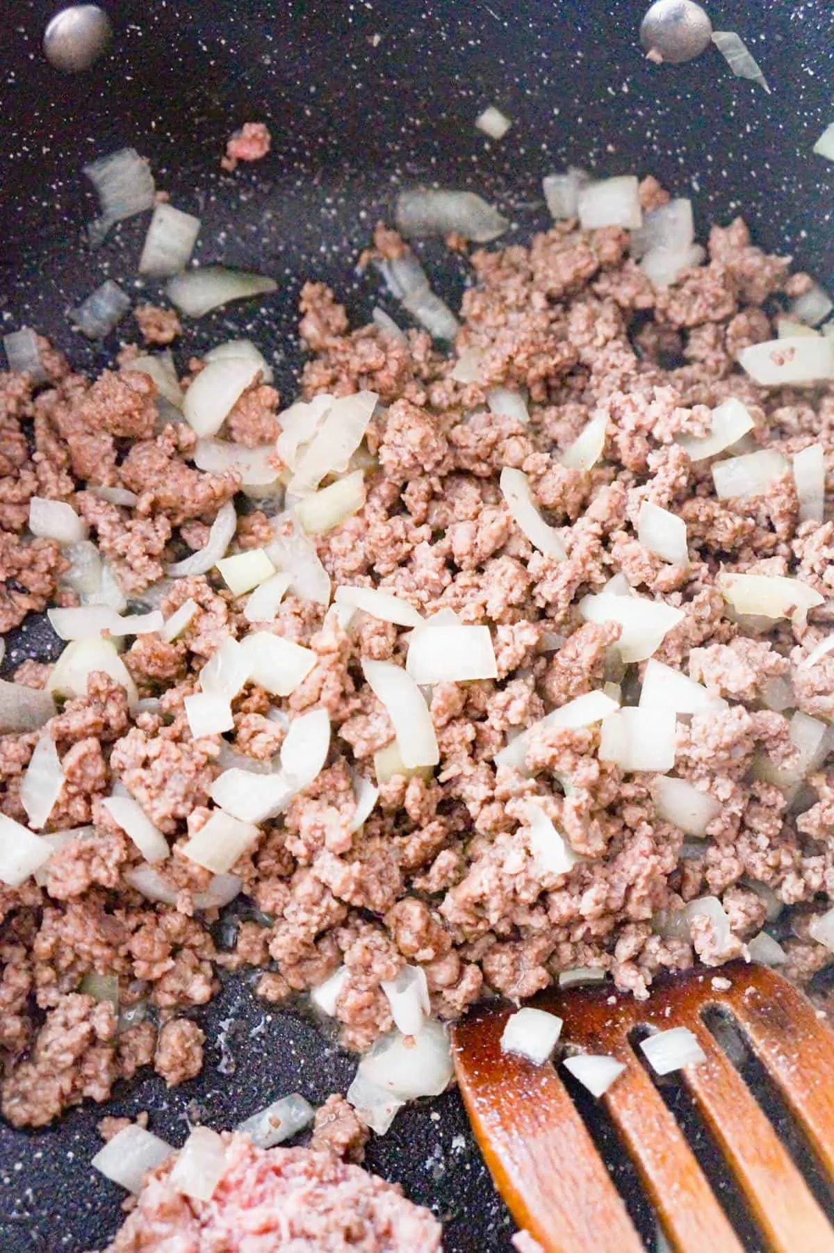 ground beef and onions cooking in a pan