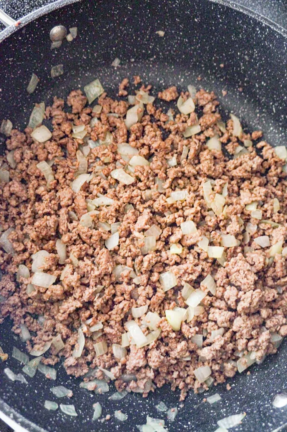 cooked ground beef and diced onions in pan