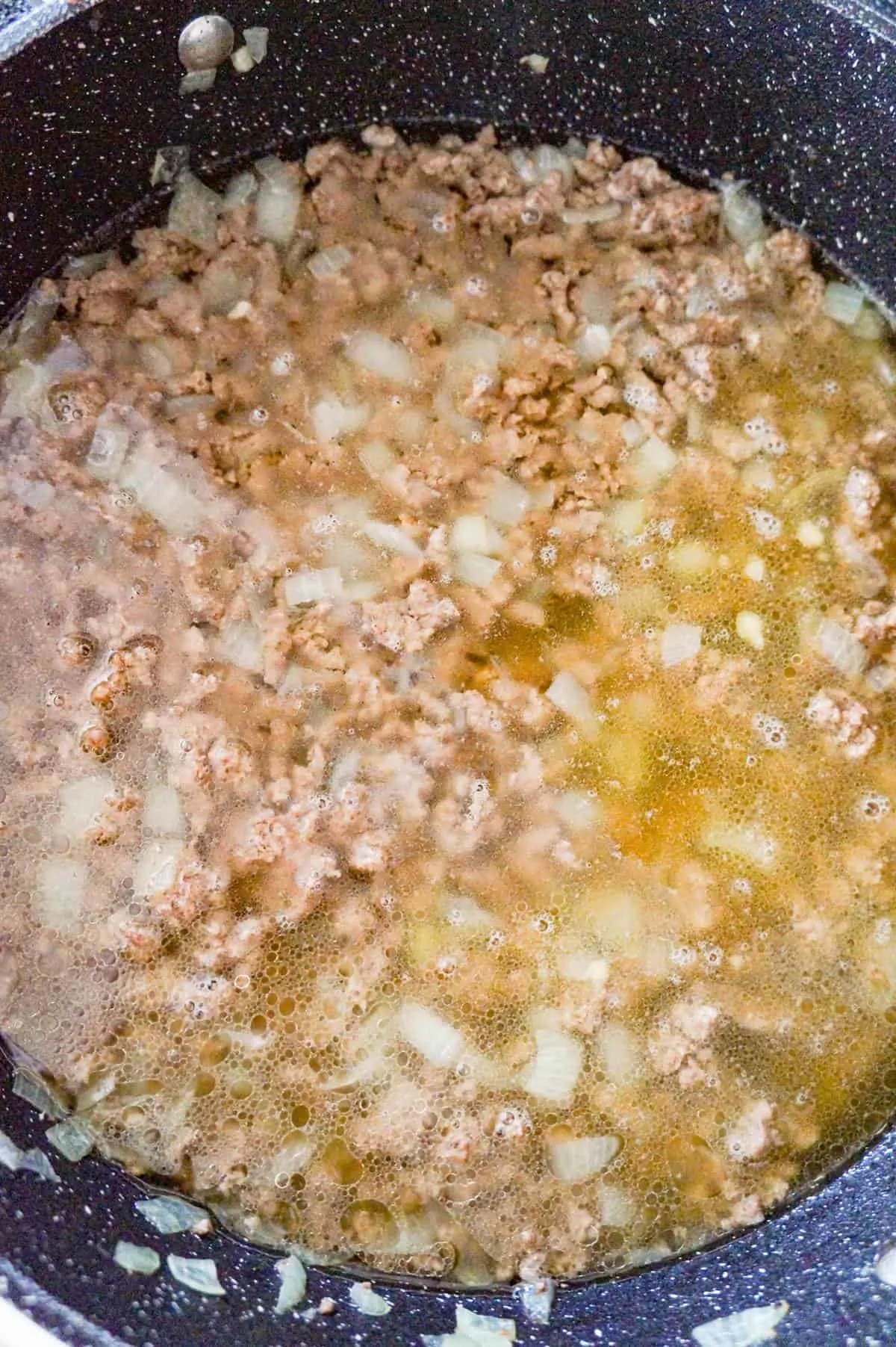 cooked ground beef in broth in a pan