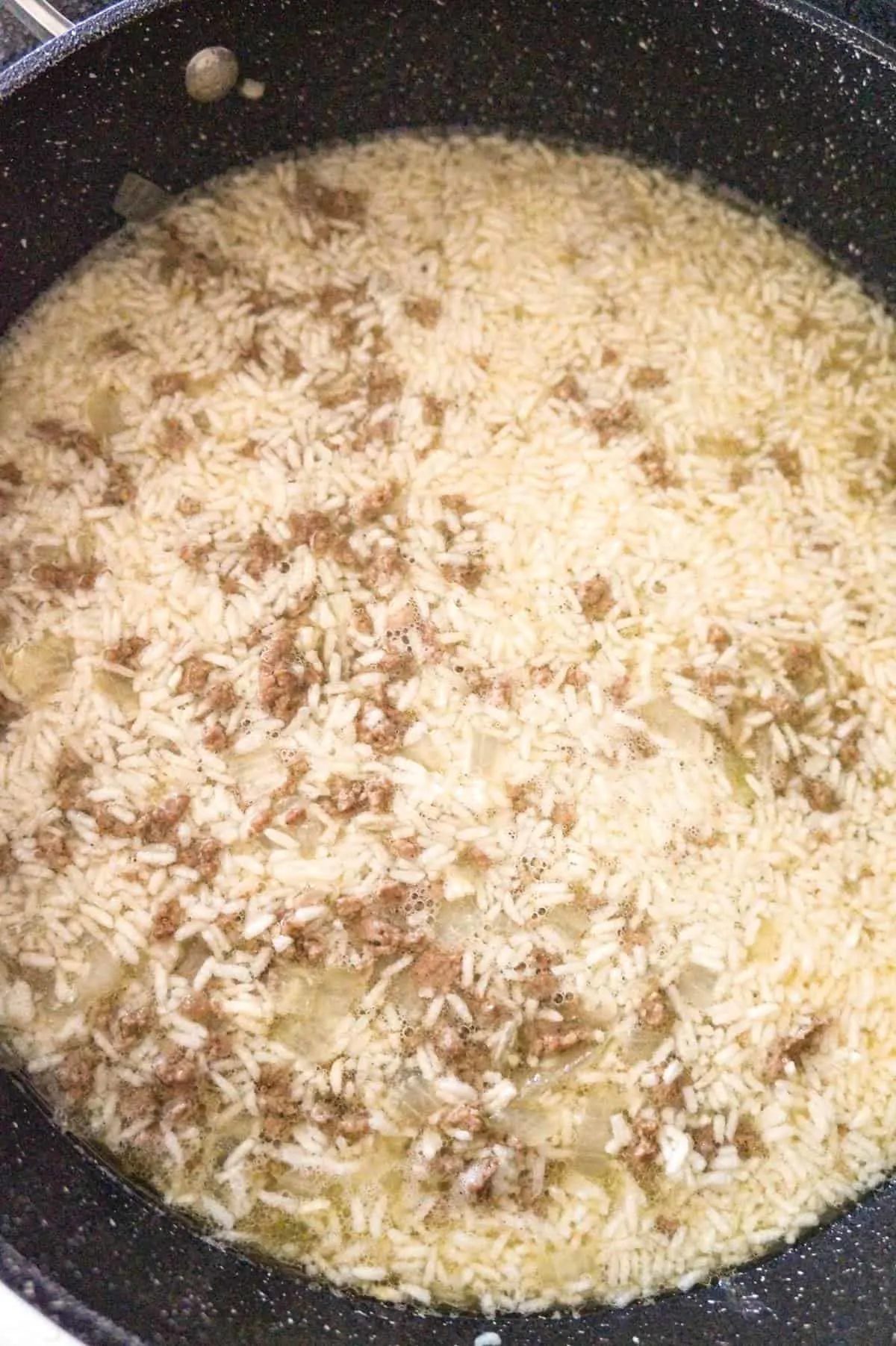 ground beef and rice cooking in a pan
